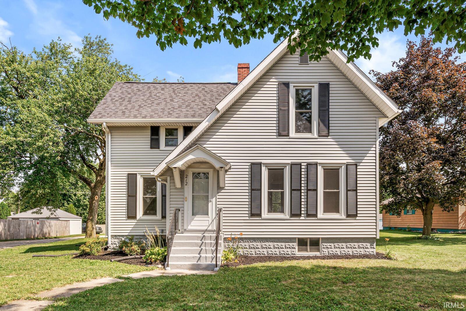 Two-story residence featuring light-colored siding and a dark shingle roof