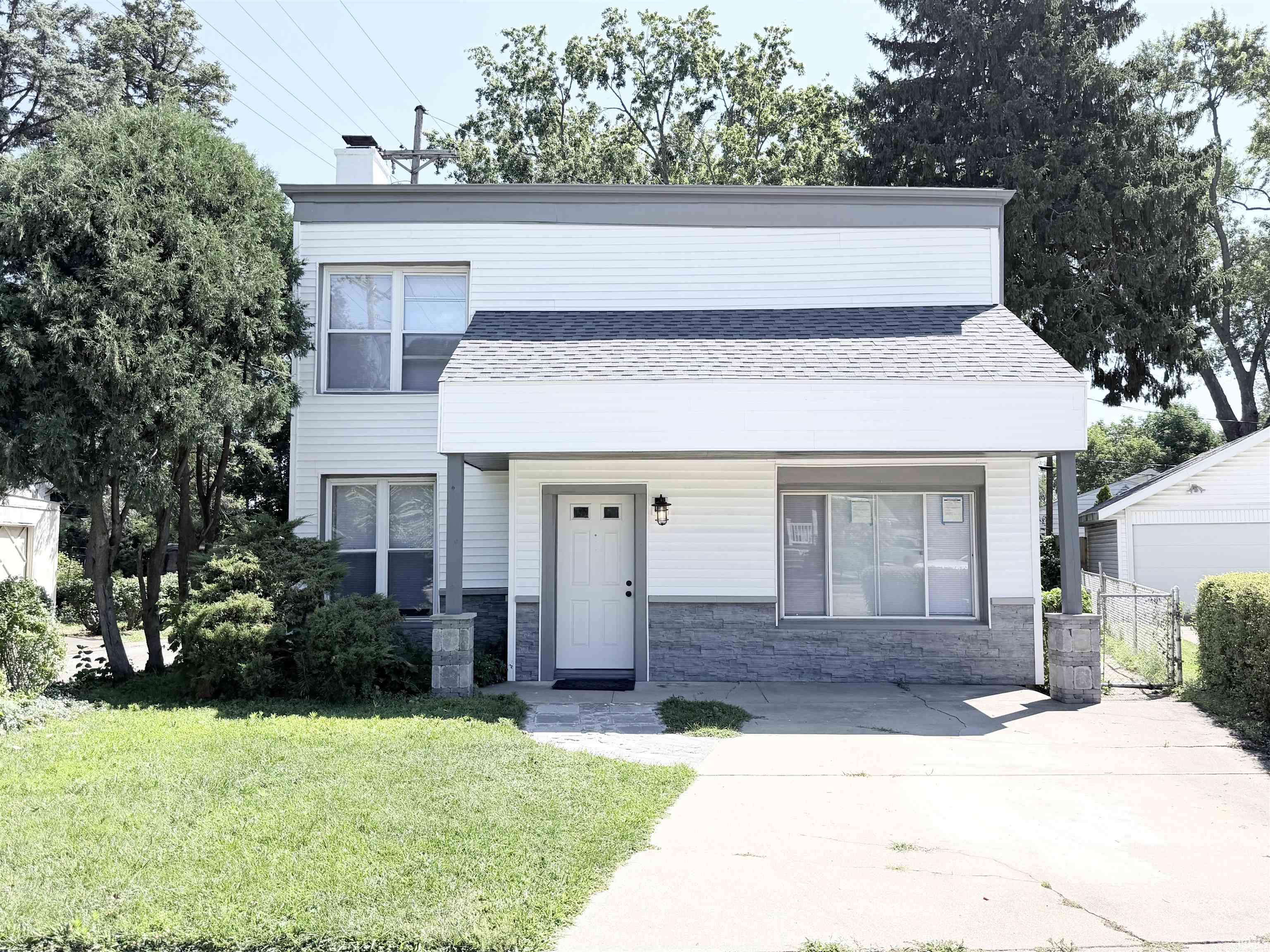 Two-story residence featuring white siding and a covered front entry
