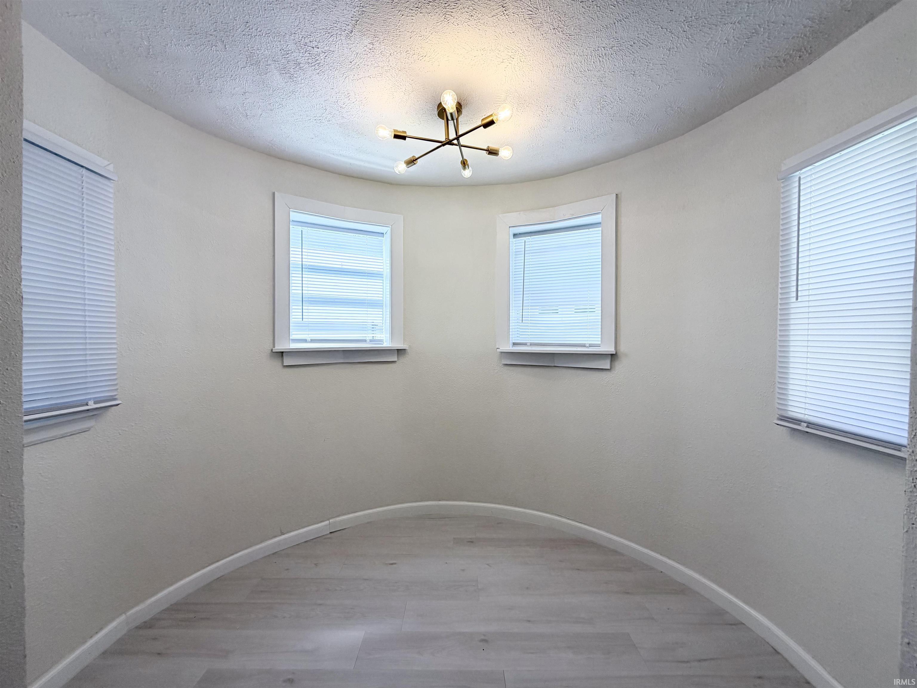 Curved interior wall with light-toned wood-finish flooring