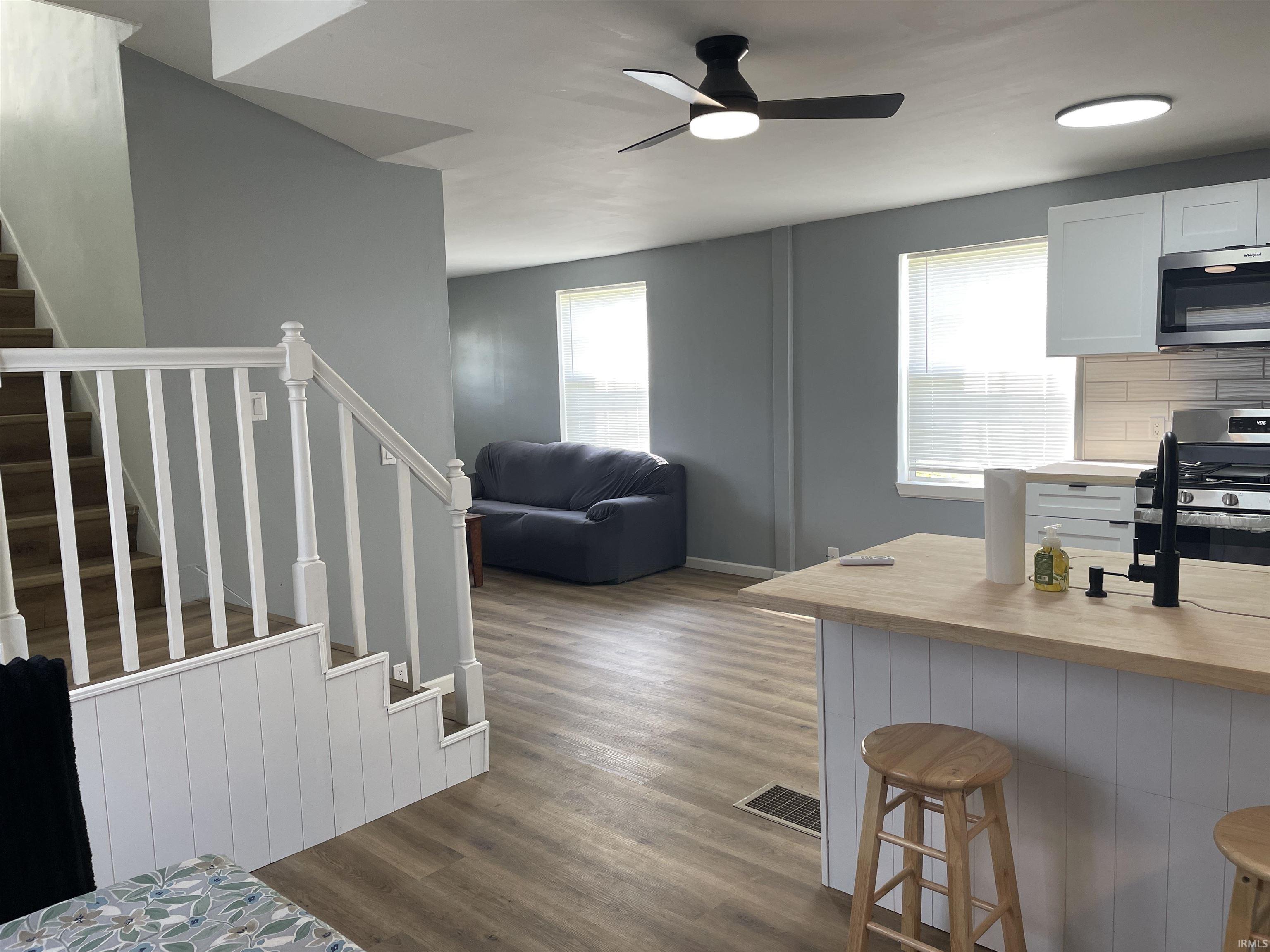 Updated kitchen with light wood-finish countertops and white cabinetry