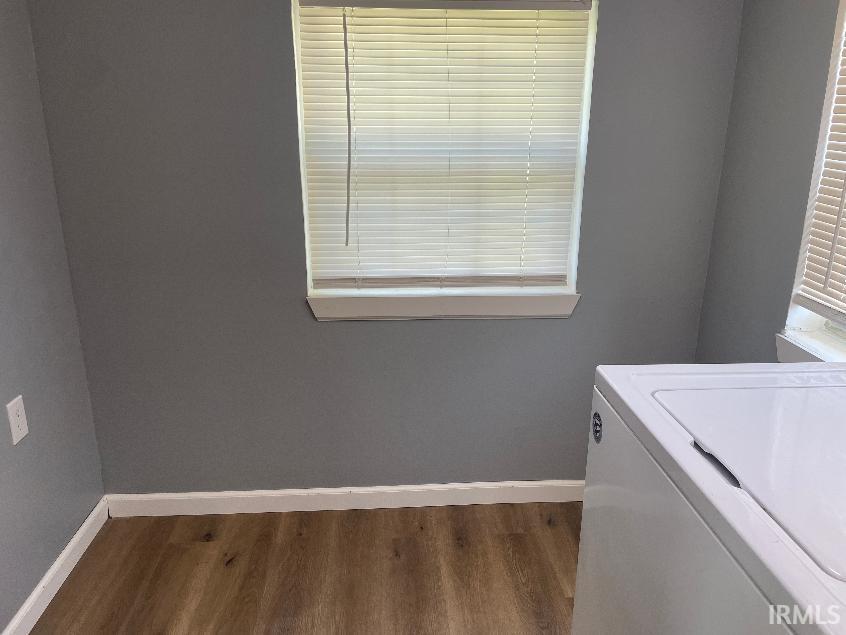 Utility area featuring wood-finish flooring, light gray wall paint, and white window blinds