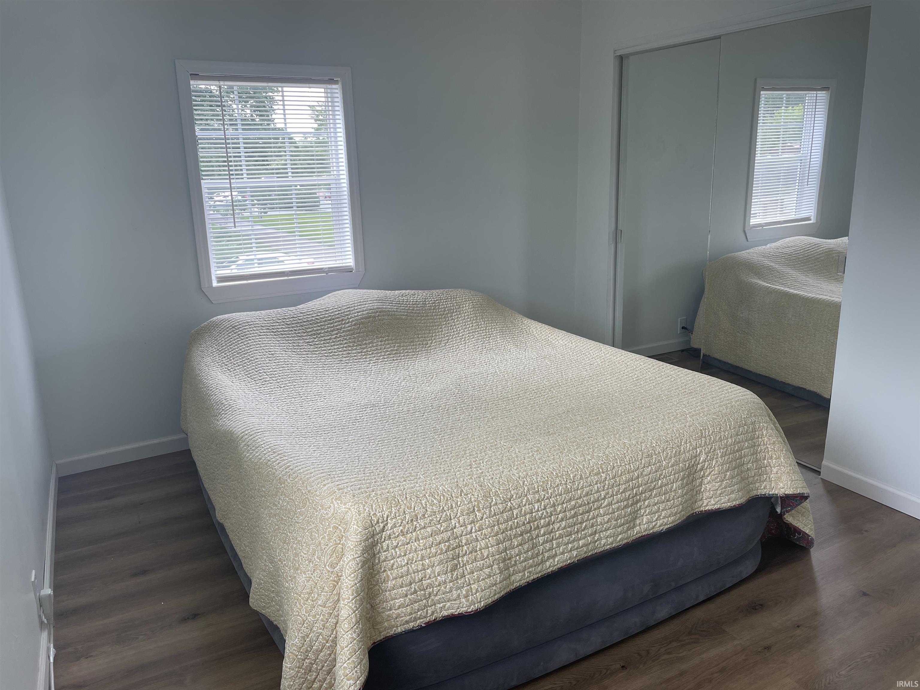Bright room featuring wood-finish flooring and a window with blinds