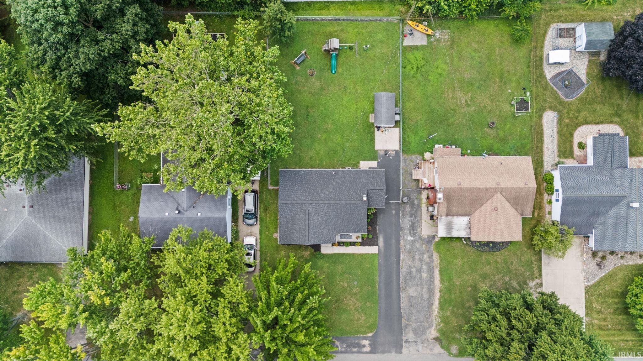 Property featuring a large, manicured lawn with mature perimeter trees