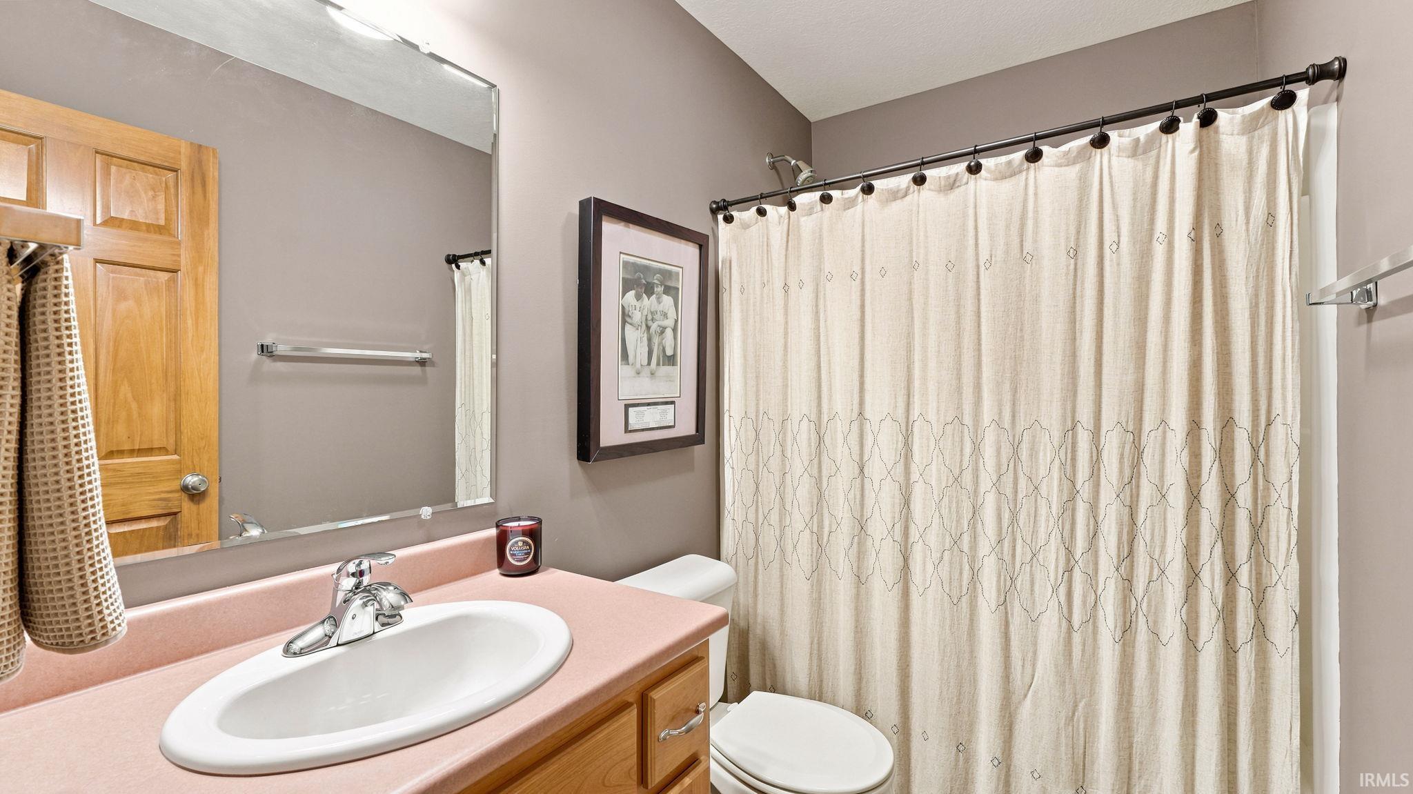 Bathroom featuring a built-in vanity with a pink countertop and integrated oval sink