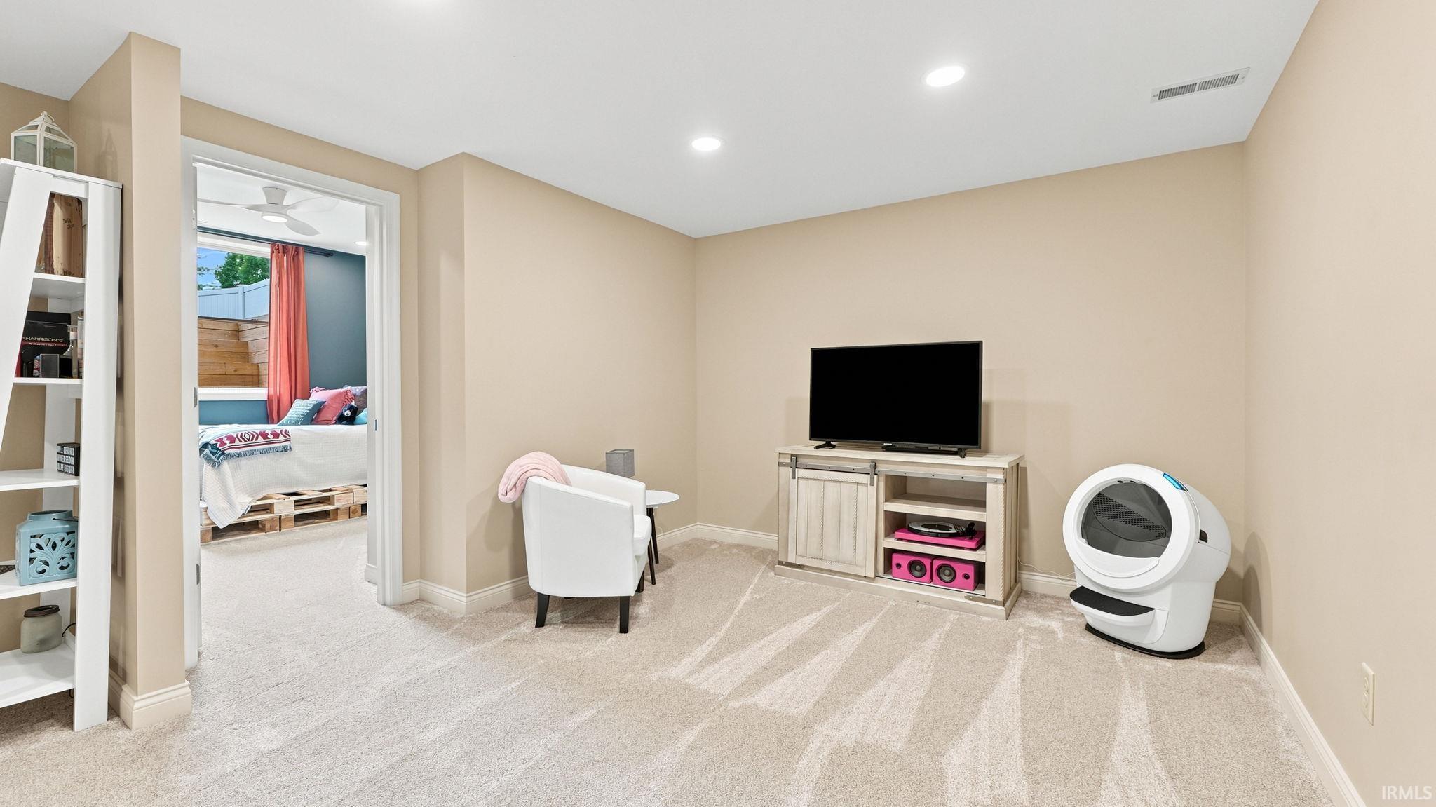Carpeted room with recessed lighting, an open doorway, and a built-in shelving unit