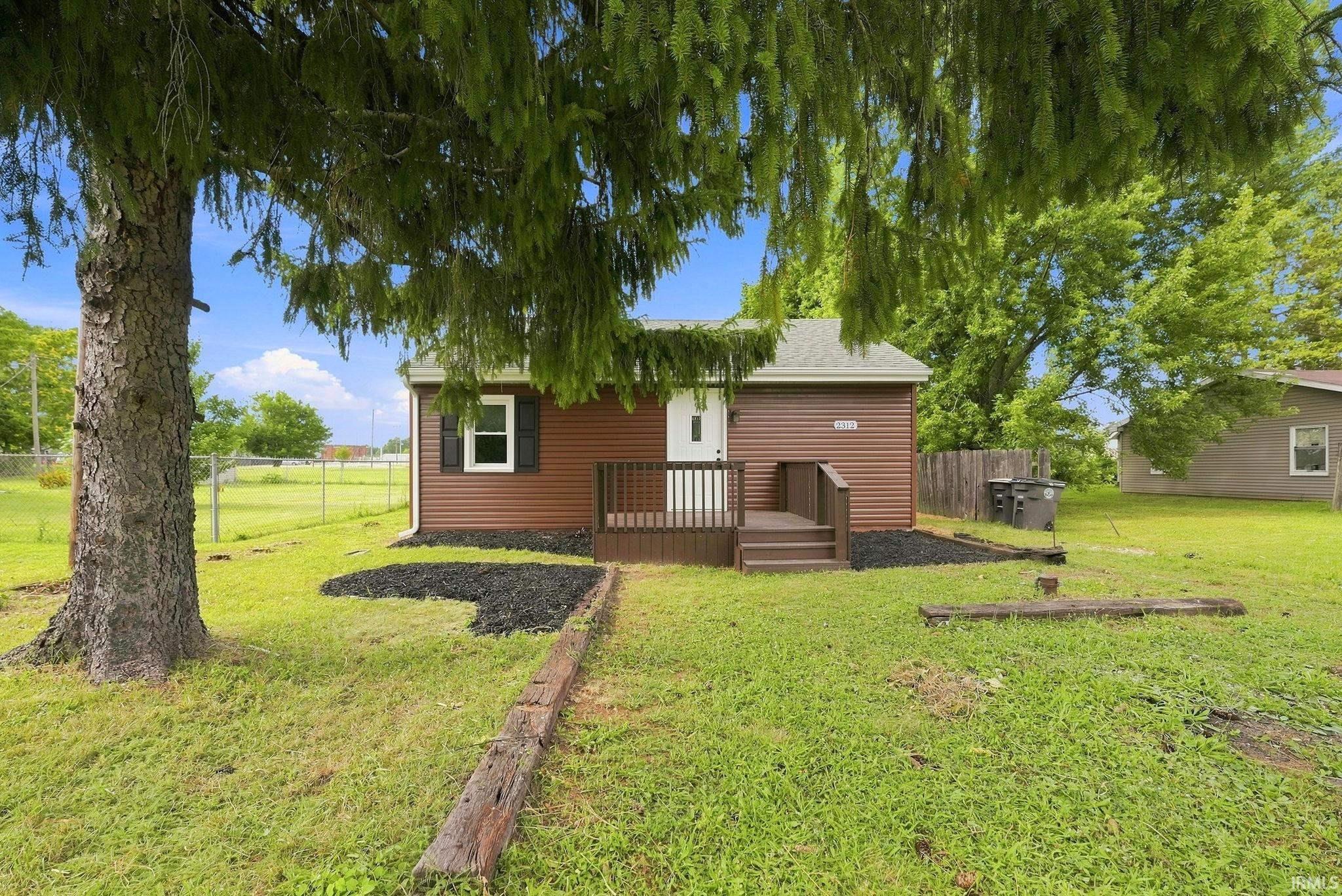 Brown horizontal siding exterior with a white front door and black shutters