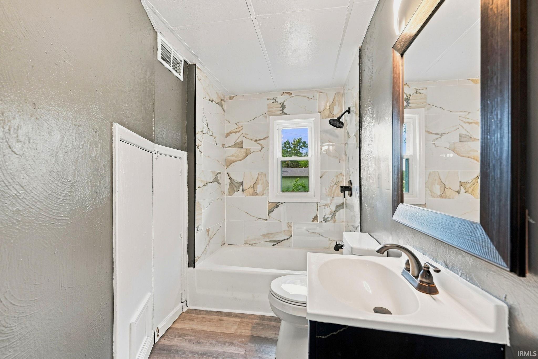 Bathroom featuring a single vanity with an integrated sink, bronze-finish faucet, and a framed mirror