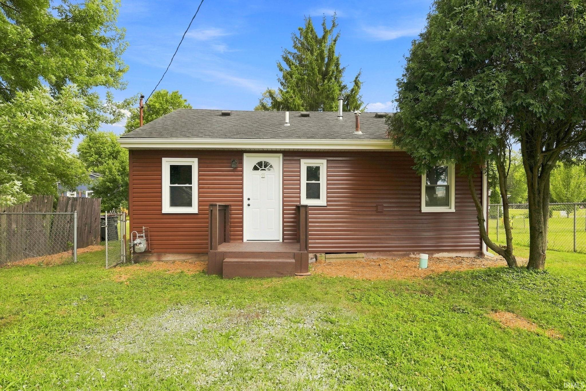 Red horizontal siding exterior with a white entry door and white window frames
