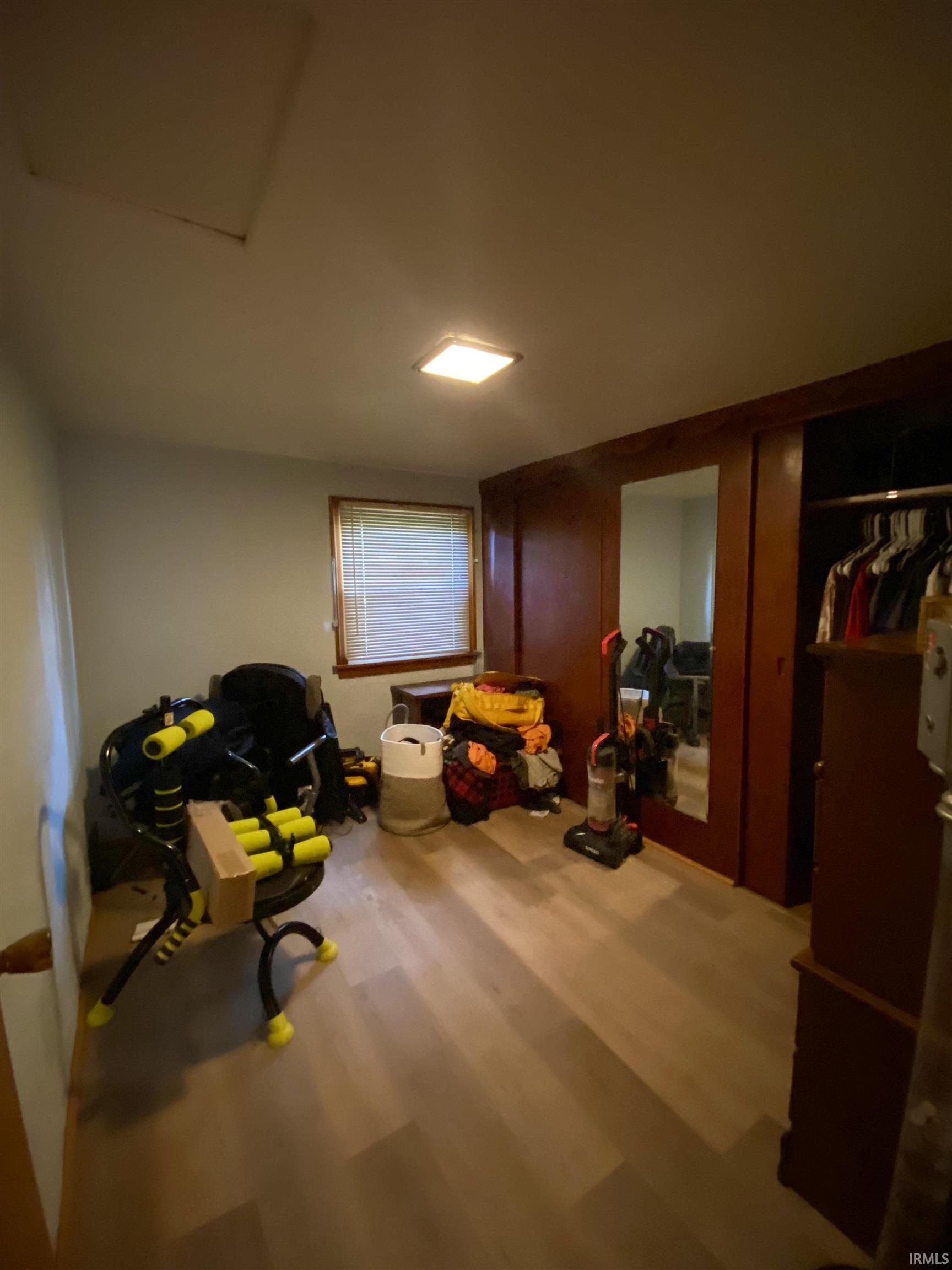 Light wood-finish flooring with a window offering natural light