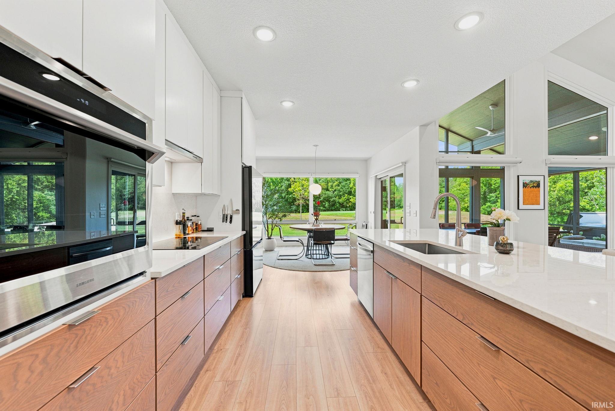 Modern kitchen featuring wood-finish lower cabinetry and white upper cabinets