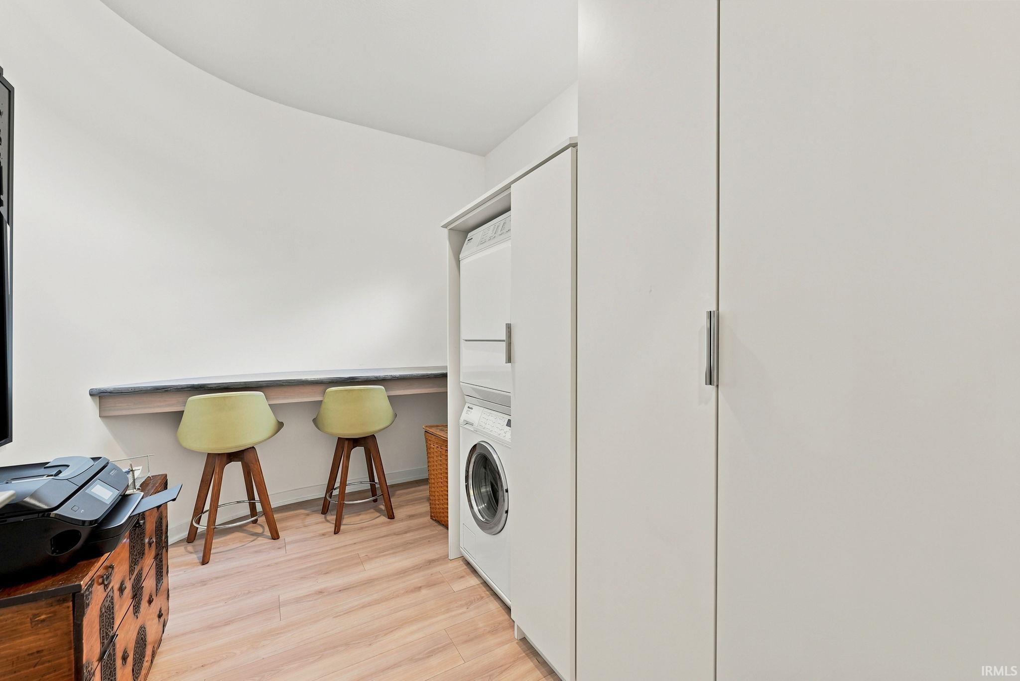 Dedicated laundry area featuring a stacked washer and dryer unit