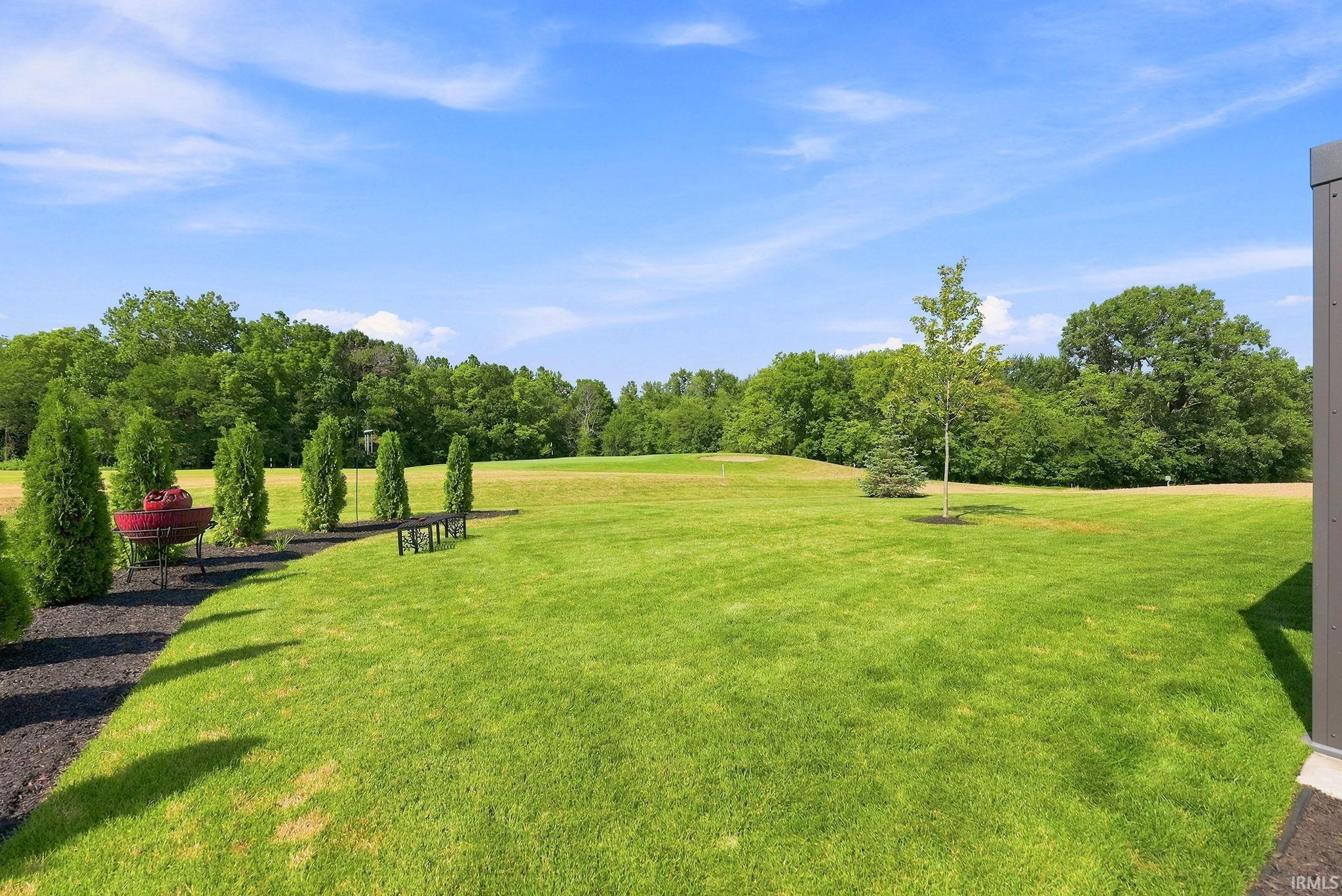 Expansive lawn featuring mature trees and a manicured landscape