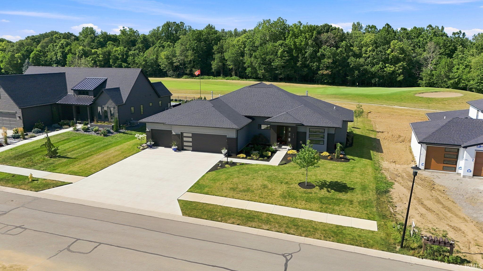 Contemporary residential property featuring a dark-toned exterior with a contrasting light-colored driveway
