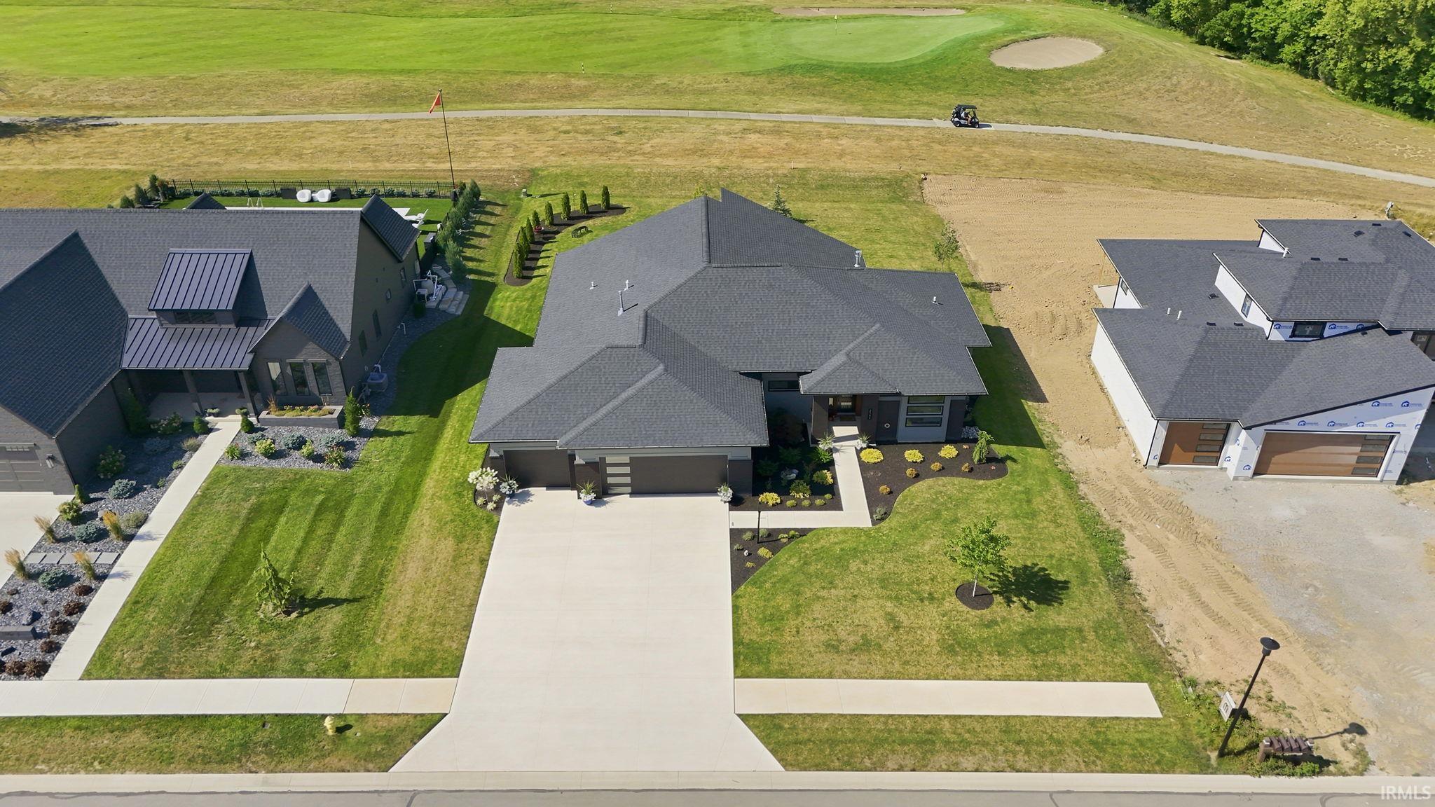 Contemporary residence featuring a dark gray exterior, attached two-car garage, and a concrete driveway