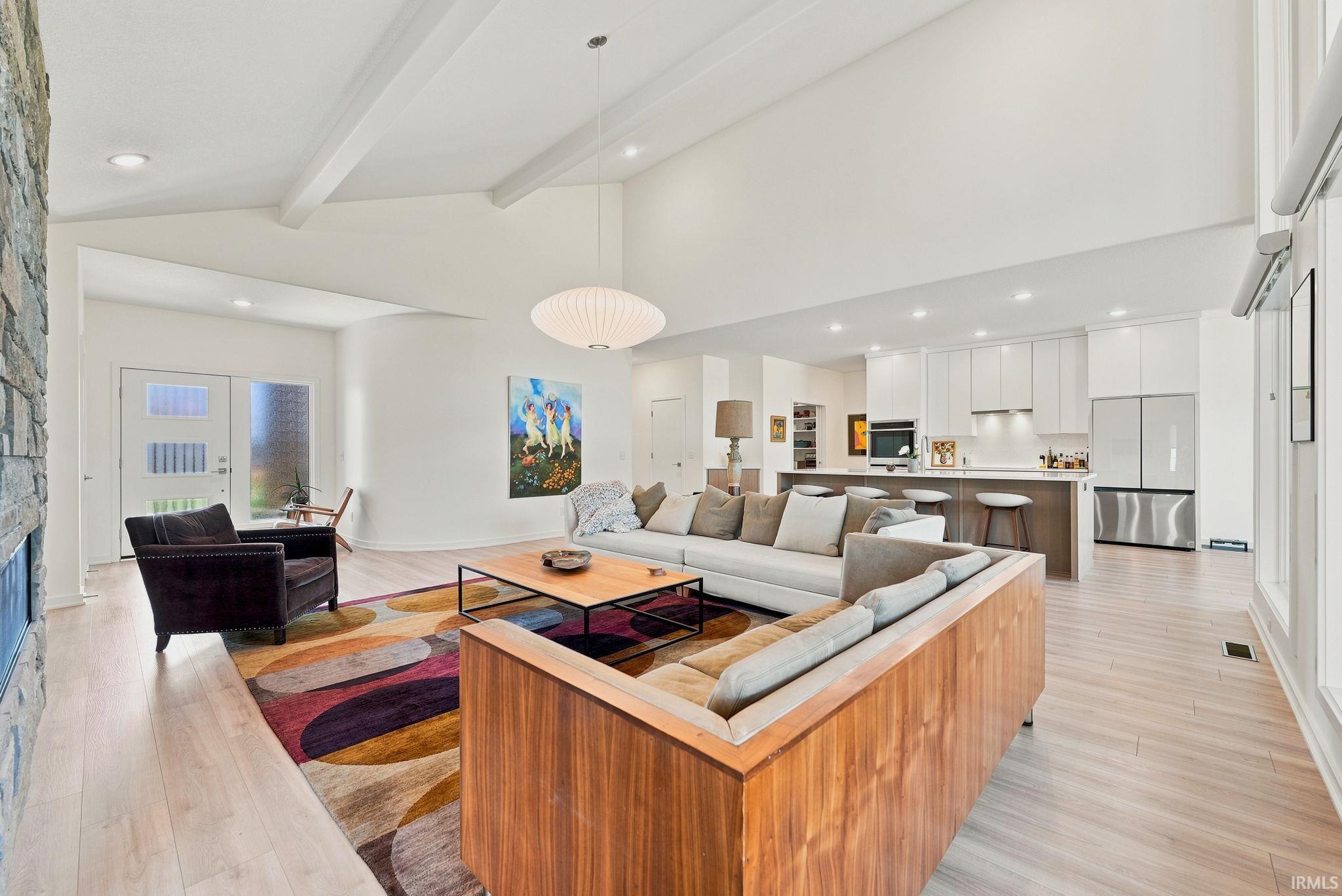 Vaulted ceilings with exposed beams complement the light wood-finish flooring
