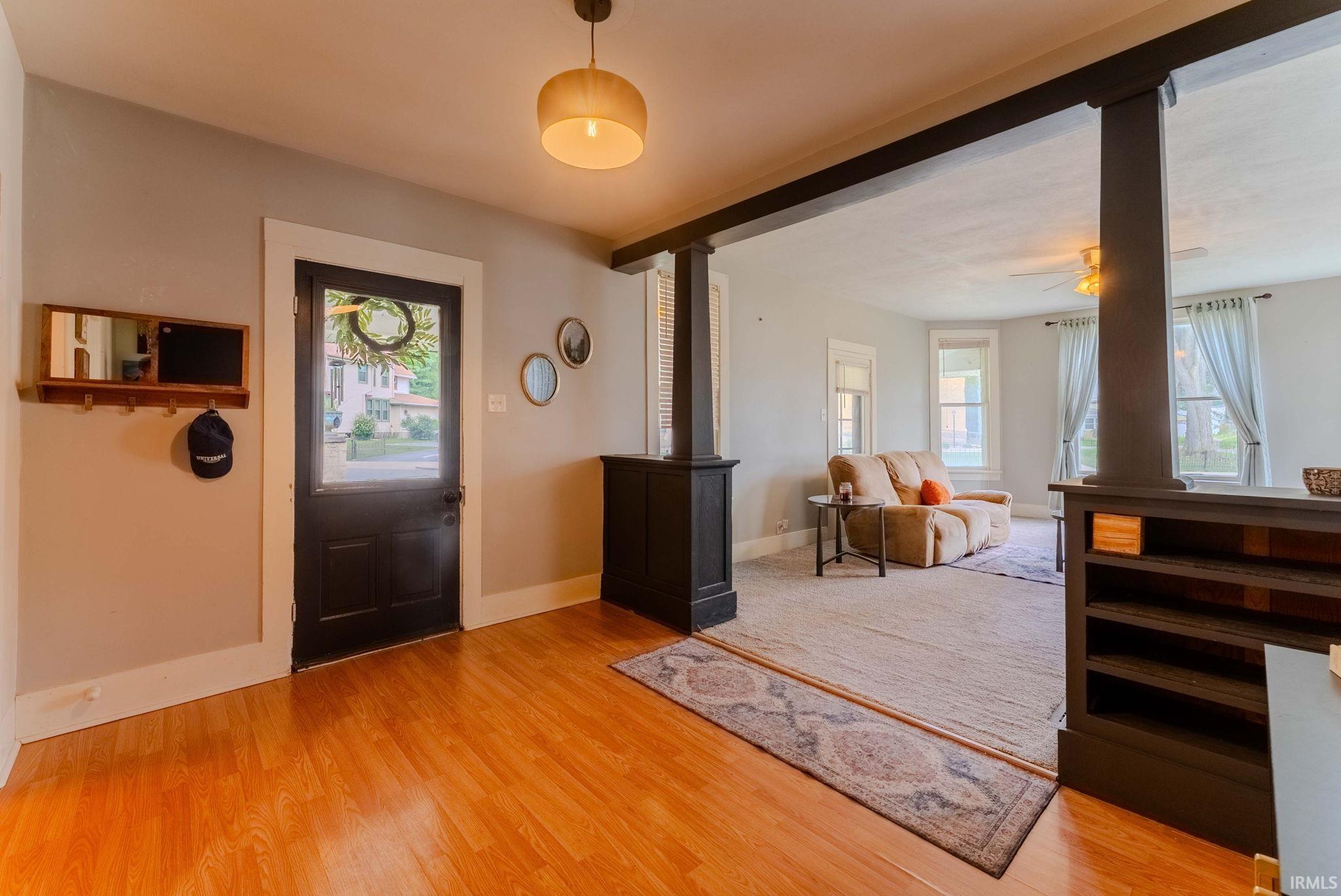 Entryway featuring wood-finish flooring and a black paneled door with a clear glass insert