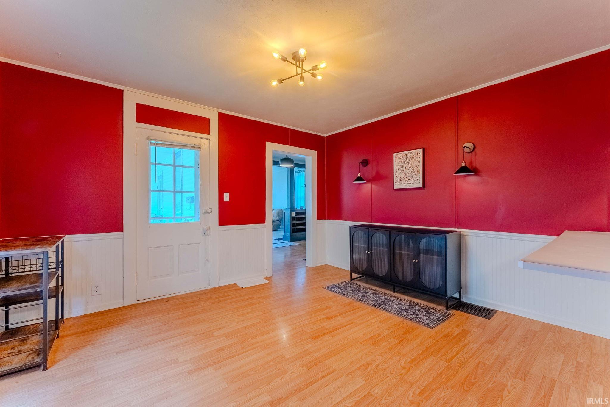 Open room with wood-finish flooring and wainscoting