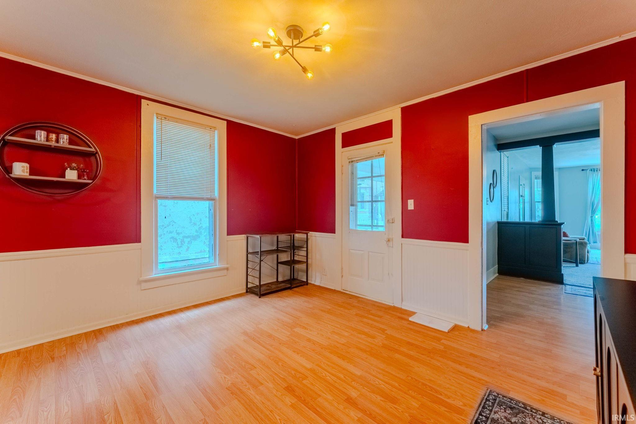 Spacious room featuring wood-finish flooring and a contemporary multi-bulb ceiling fixture