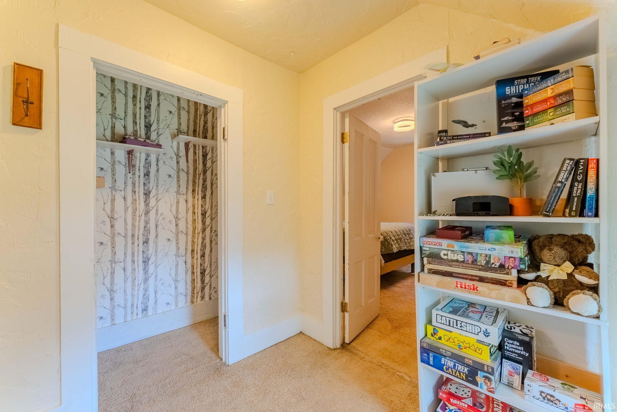 Built-in shelving unit with multiple tiers, bright wall paint, and white trim molding