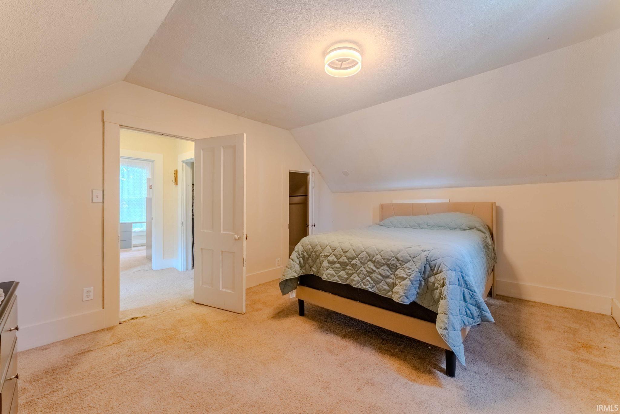 Attic room with sloped ceilings and carpet flooring