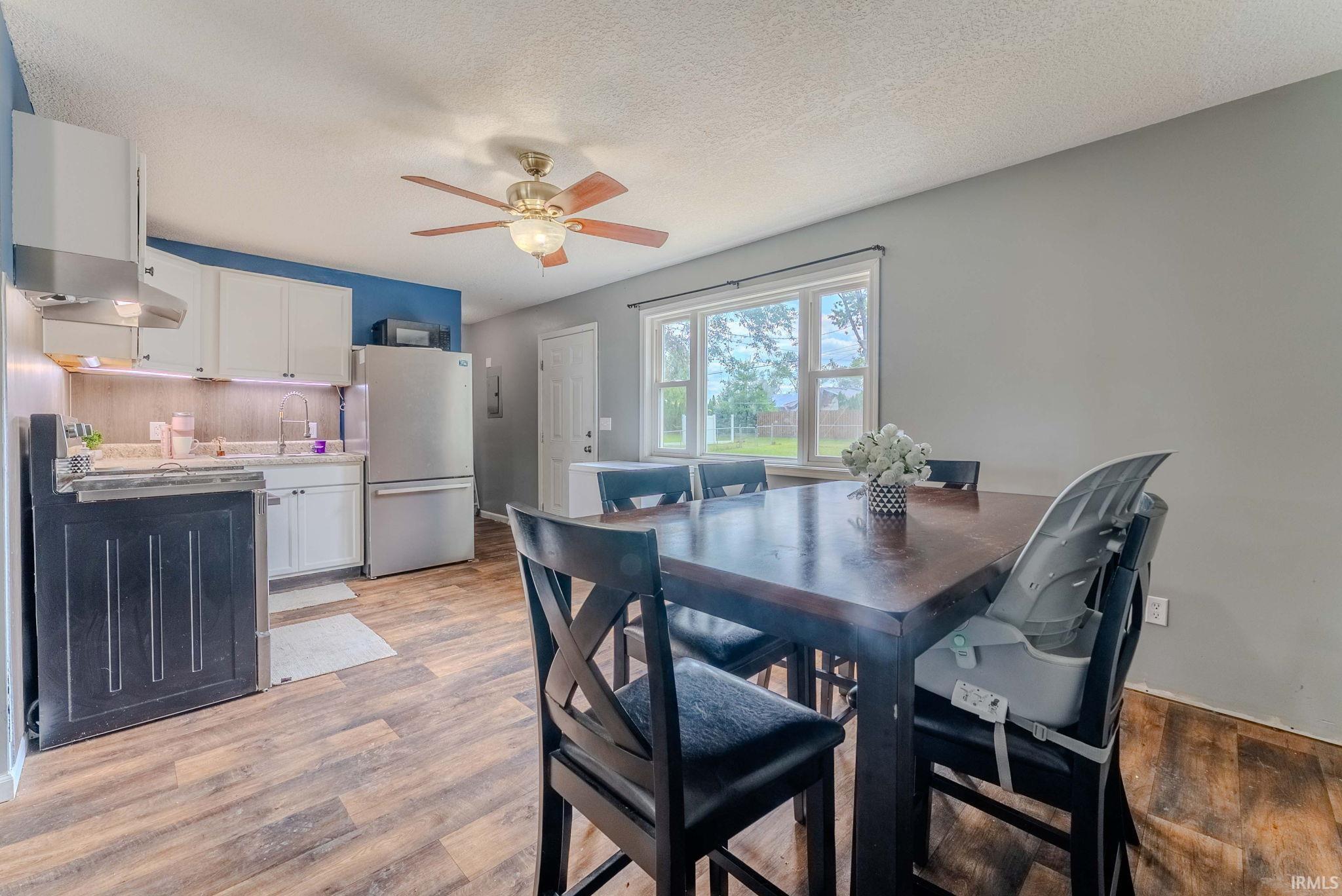 Open-concept kitchen and dining area with wood-finish flooring