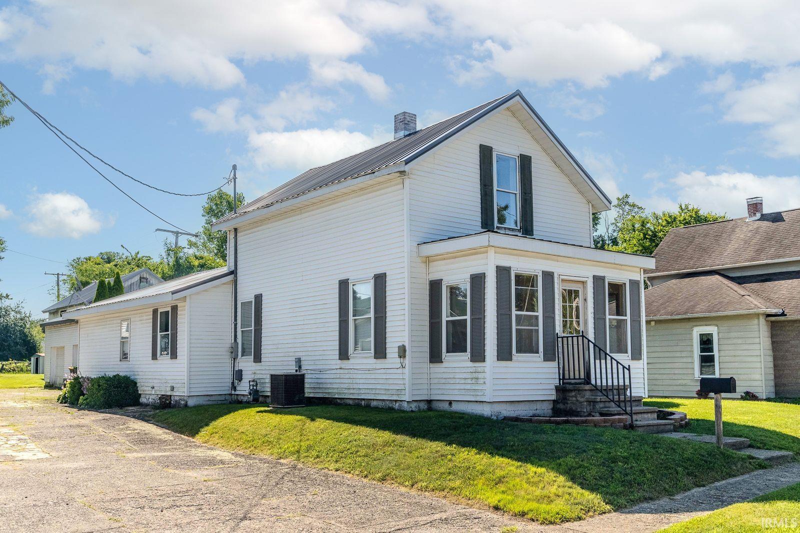 Two-story exterior featuring white siding and dark louvered shutters