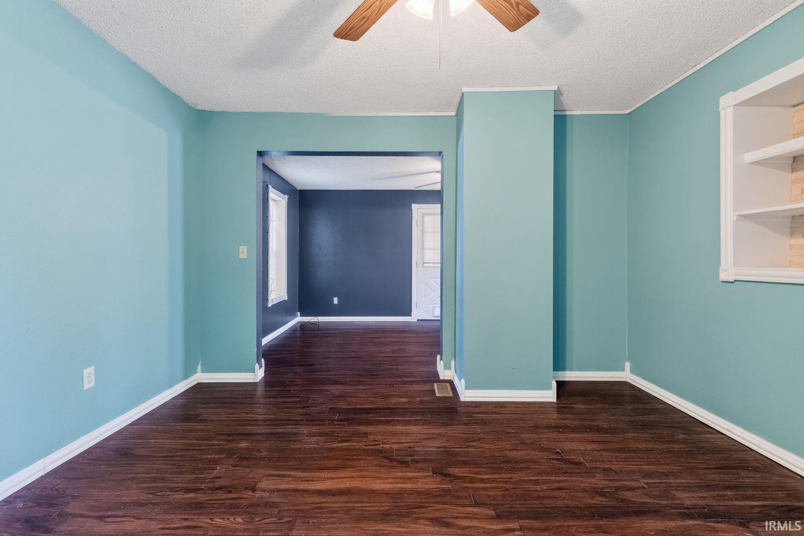 Rich wood-finish flooring complements the vibrant wall color in this interior space