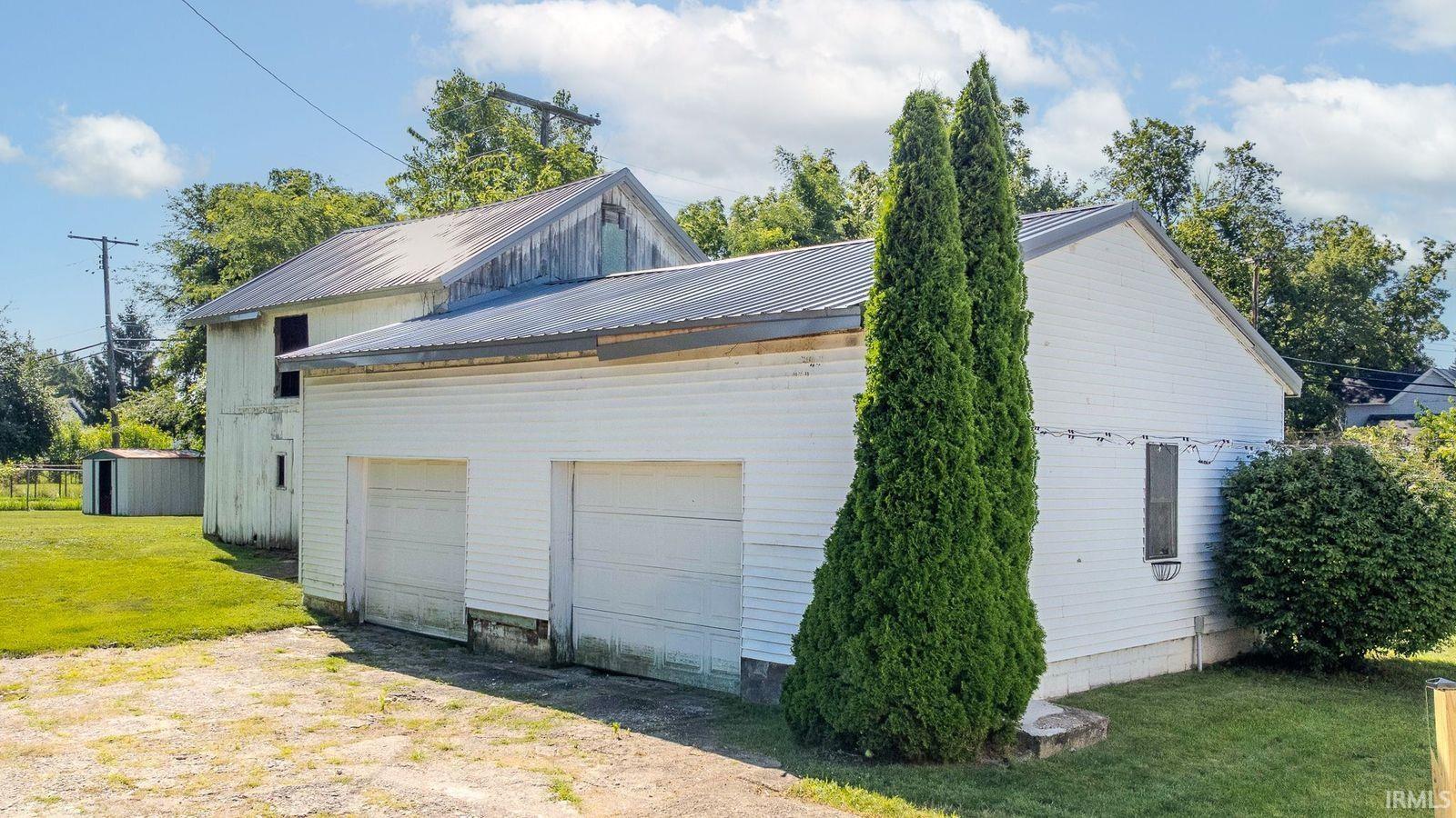 Two-car garage with white paneled doors and a metal roof