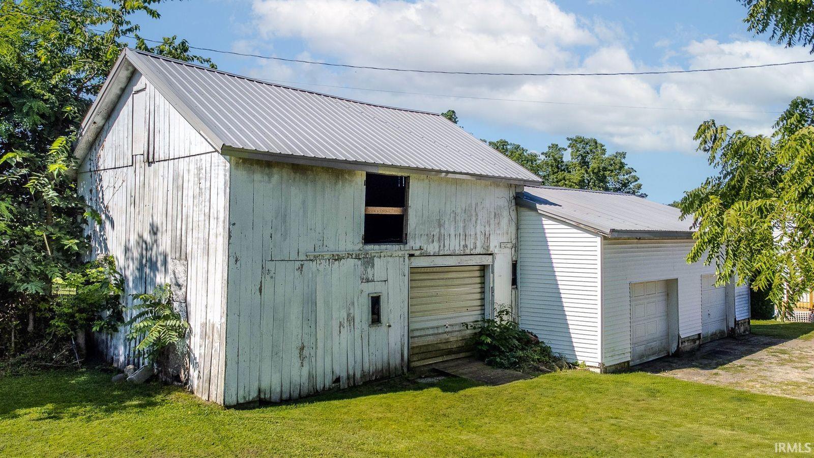 Two-story structure with a metal roof and white wood siding