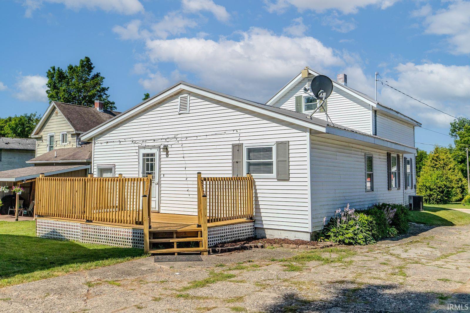 Rear exterior with white siding and a wood deck