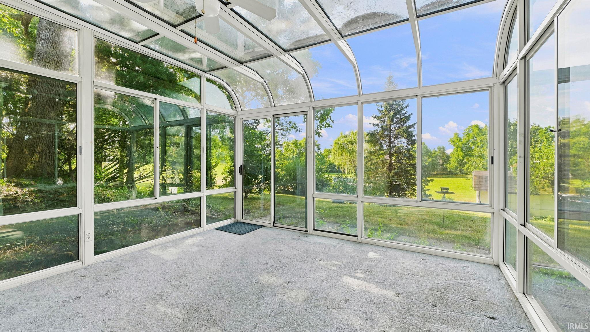 Sunroom featuring a glass-paneled ceiling, floor-to-ceiling windows, and a sliding glass door