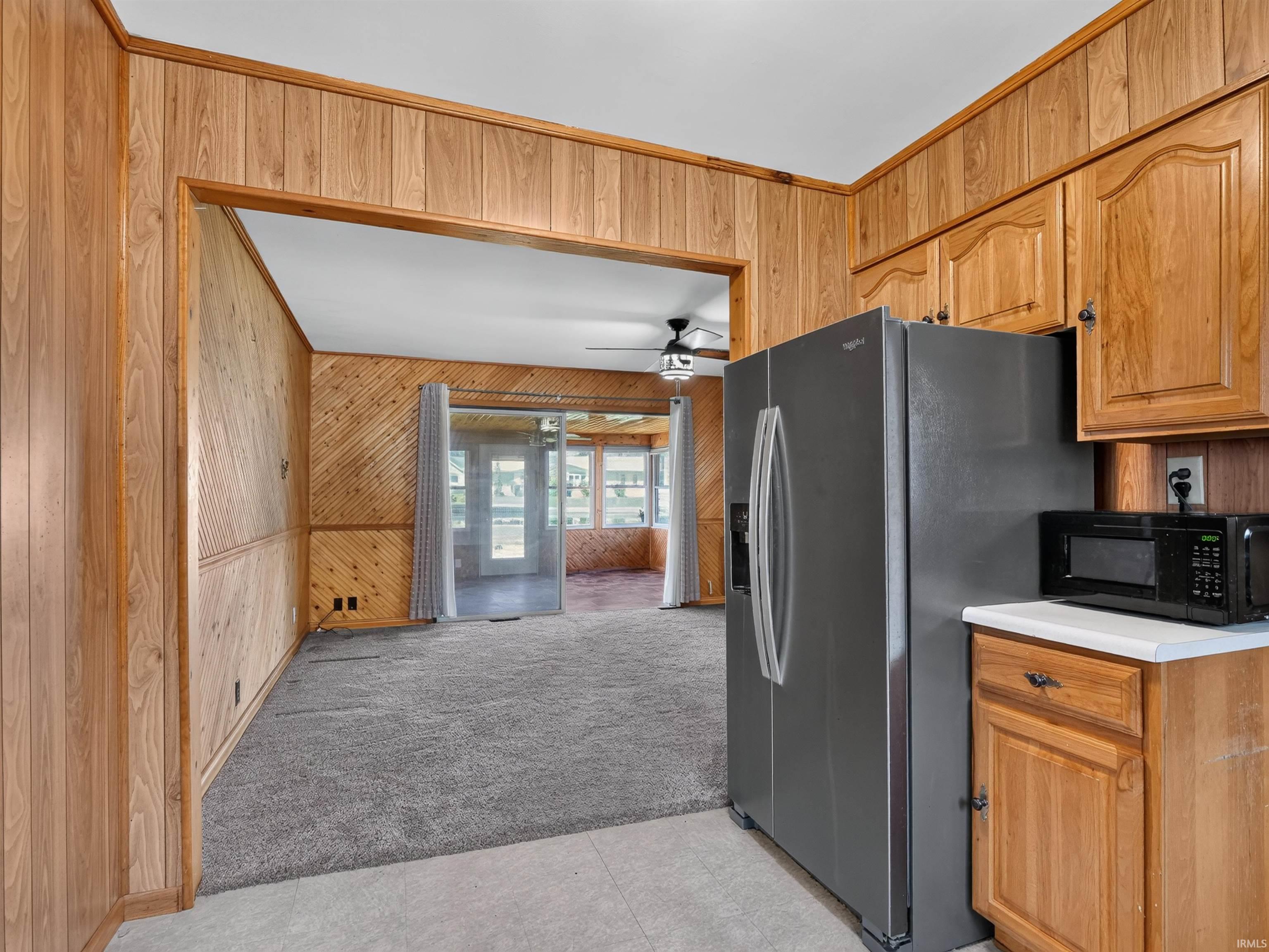 Kitchen area featuring wood cabinetry, white countertop, and a stainless steel refrigerator