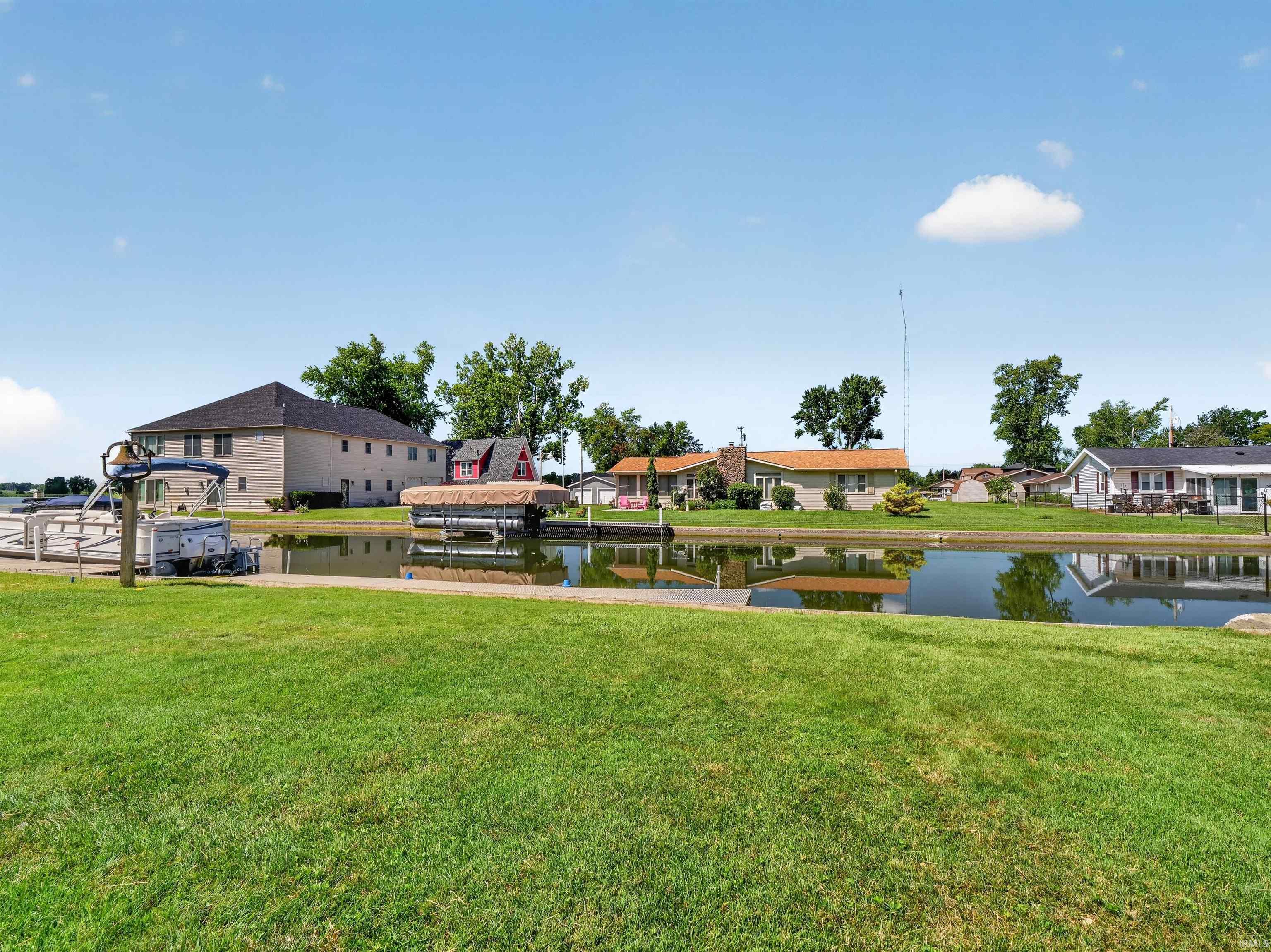 Expansive green lawn with a water canal and private boat dock