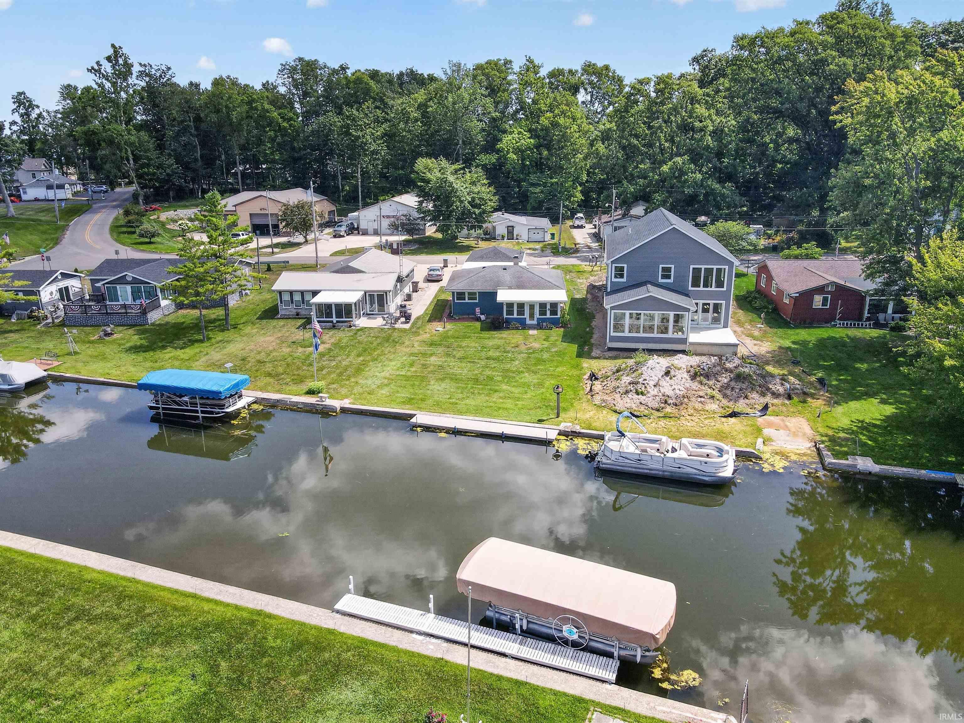 Waterfront property featuring a two-story residence with a sunroom addition and extensive fenestration