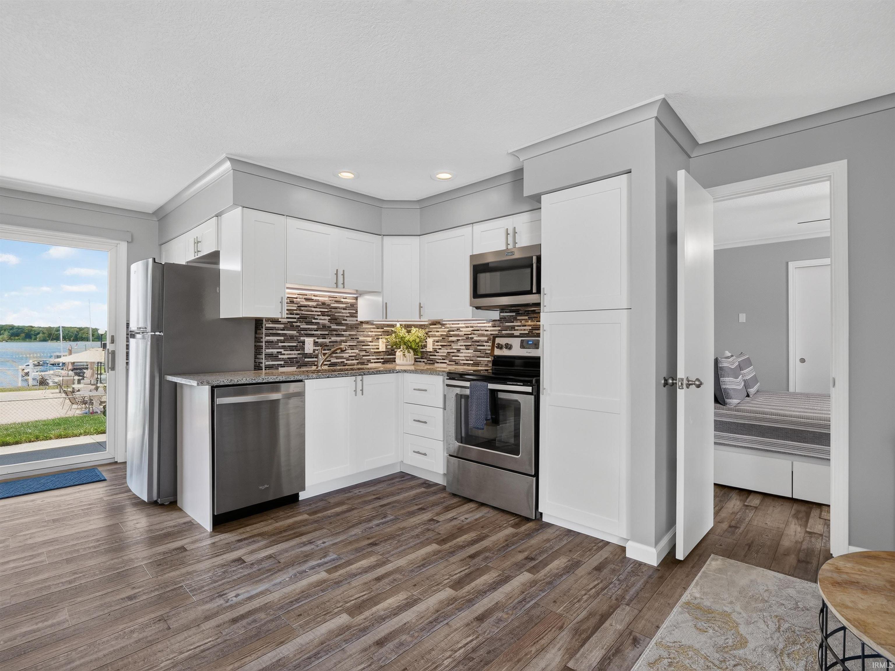 Modern kitchen featuring white cabinetry, stainless steel appliances, and a tiled backsplash