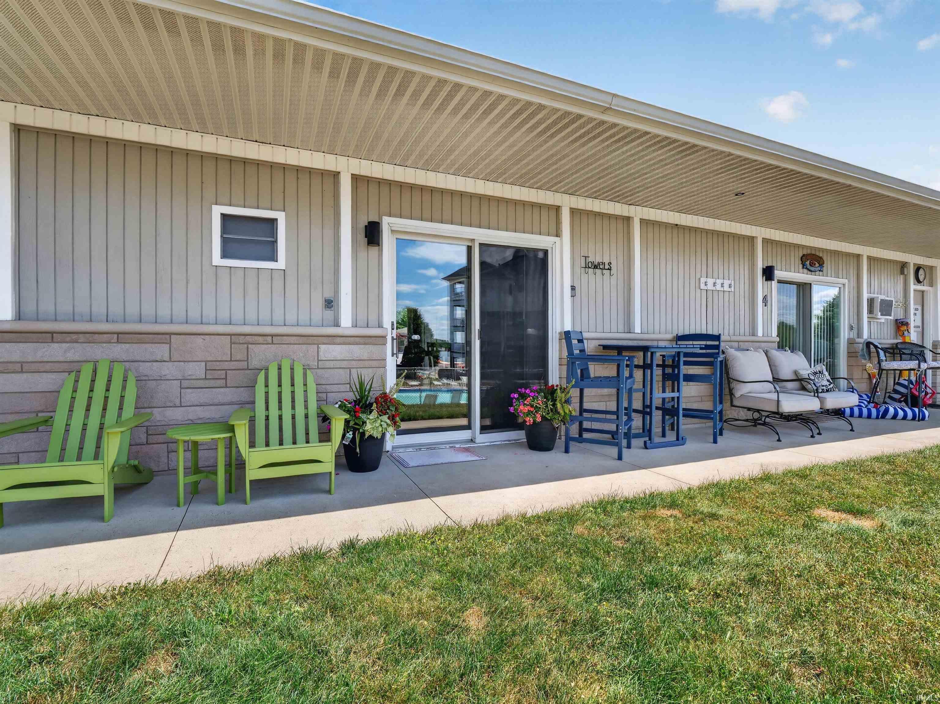 Ground-level patio featuring a stone facade, vertical siding, and a soffit ceiling