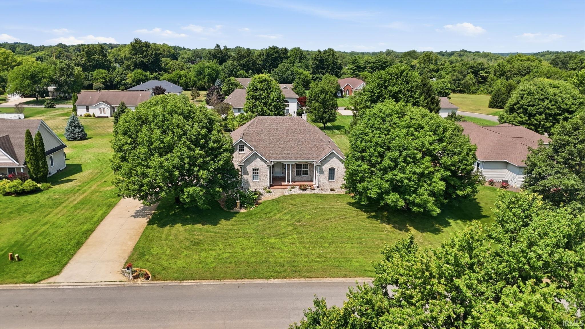 Ranch-style residence featuring a prominent front porch with columns, a shingle roof, and light-toned siding