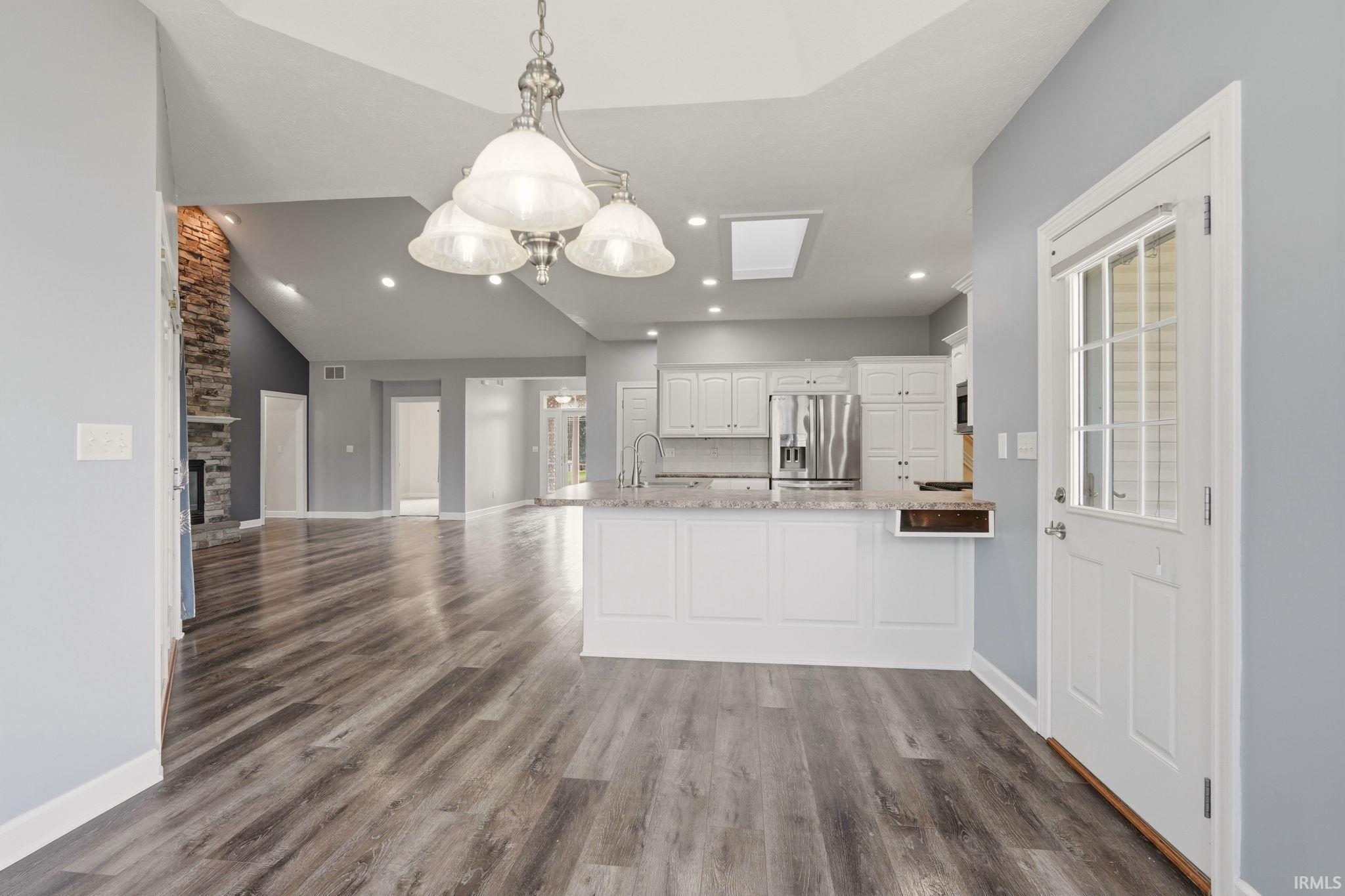 Spacious living area featuring wood-finish flooring and a vaulted ceiling