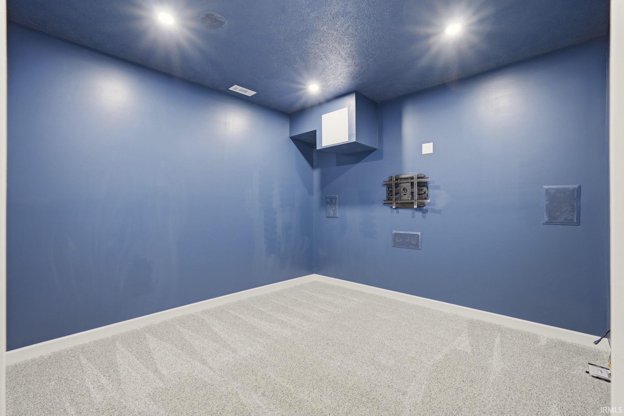 Room featuring blue painted walls, a textured blue ceiling, and recessed lighting