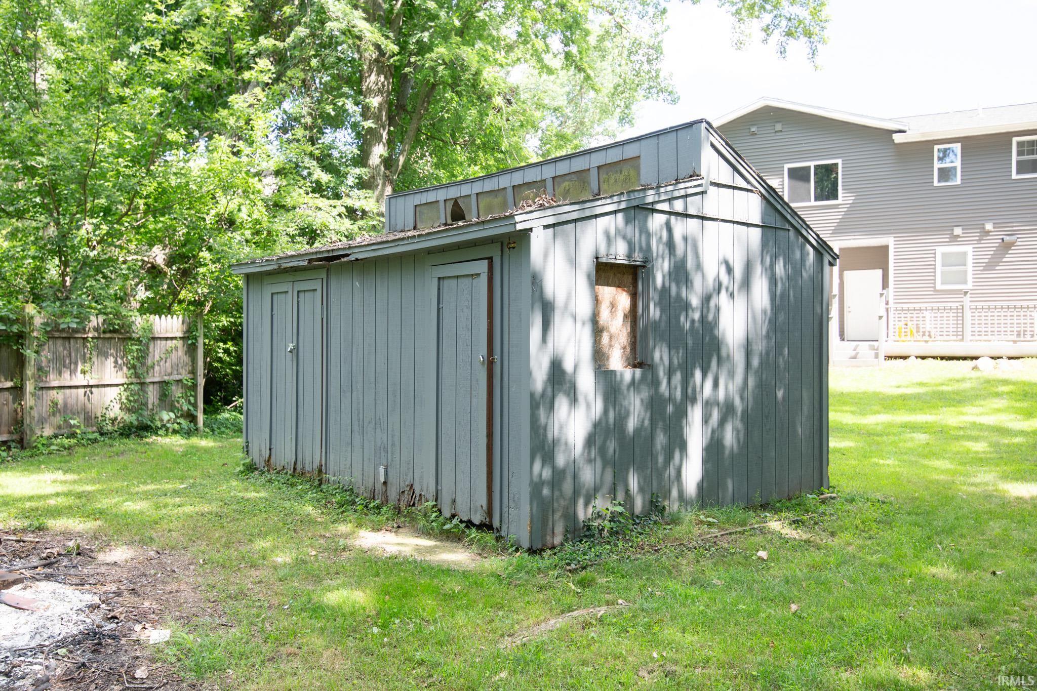 Detached shed with vertical siding, multiple access doors, and clerestory windows