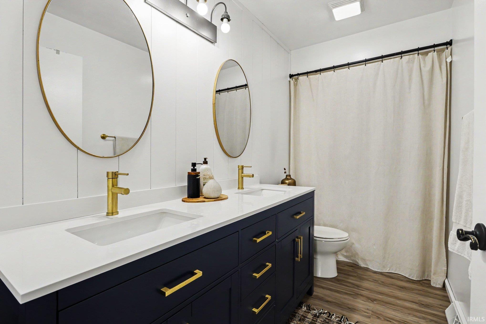 Dual vanity with a white countertop and integrated sinks, complemented by gold-finish faucets and hardware