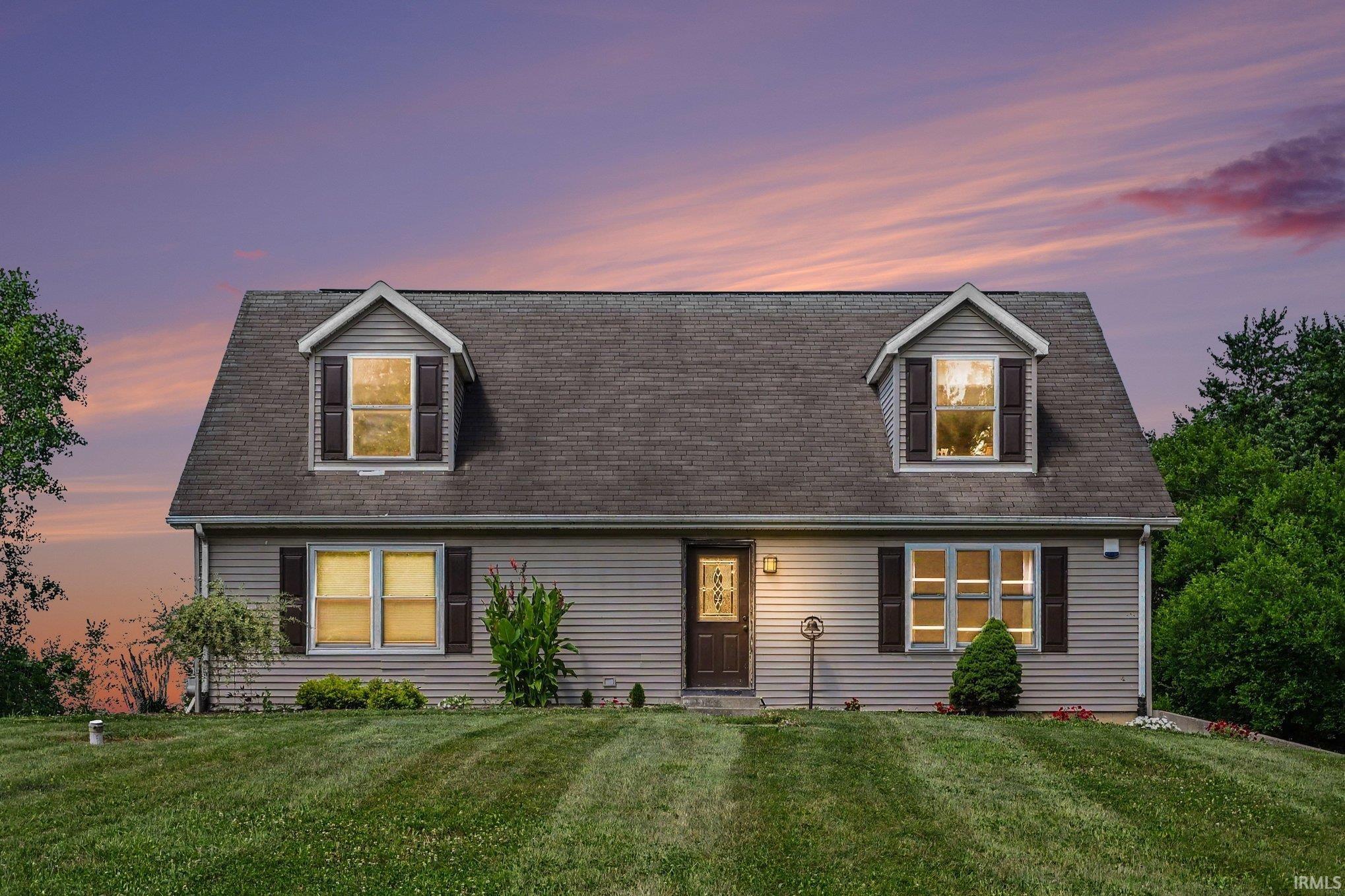 Two-story residence featuring light gray siding with dark brown window shutters