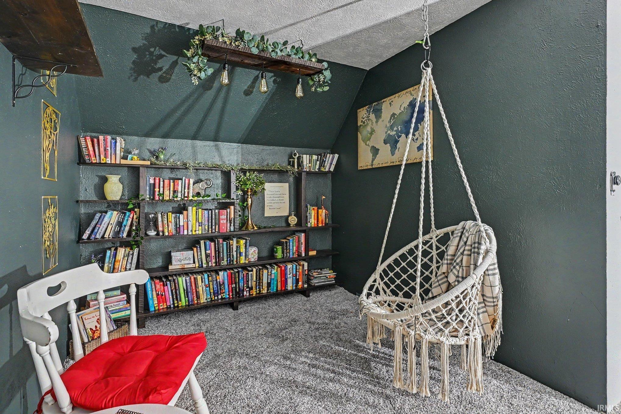 Room featuring dark painted walls, built-in shelving, and a textured ceiling
