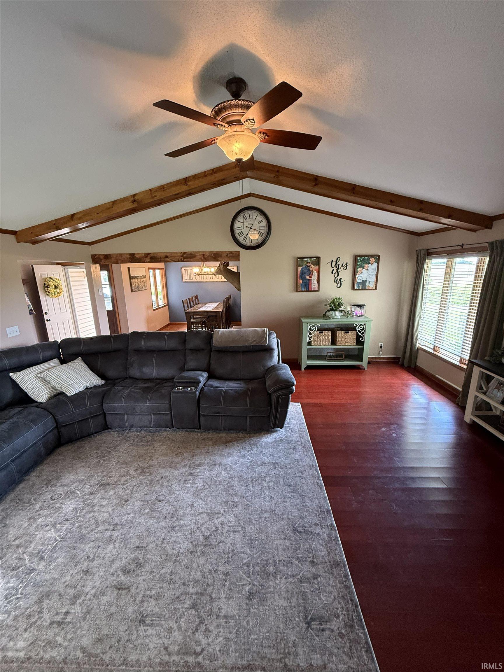 Vaulted ceiling featuring exposed wood beams and a ceiling fan with integrated lighting