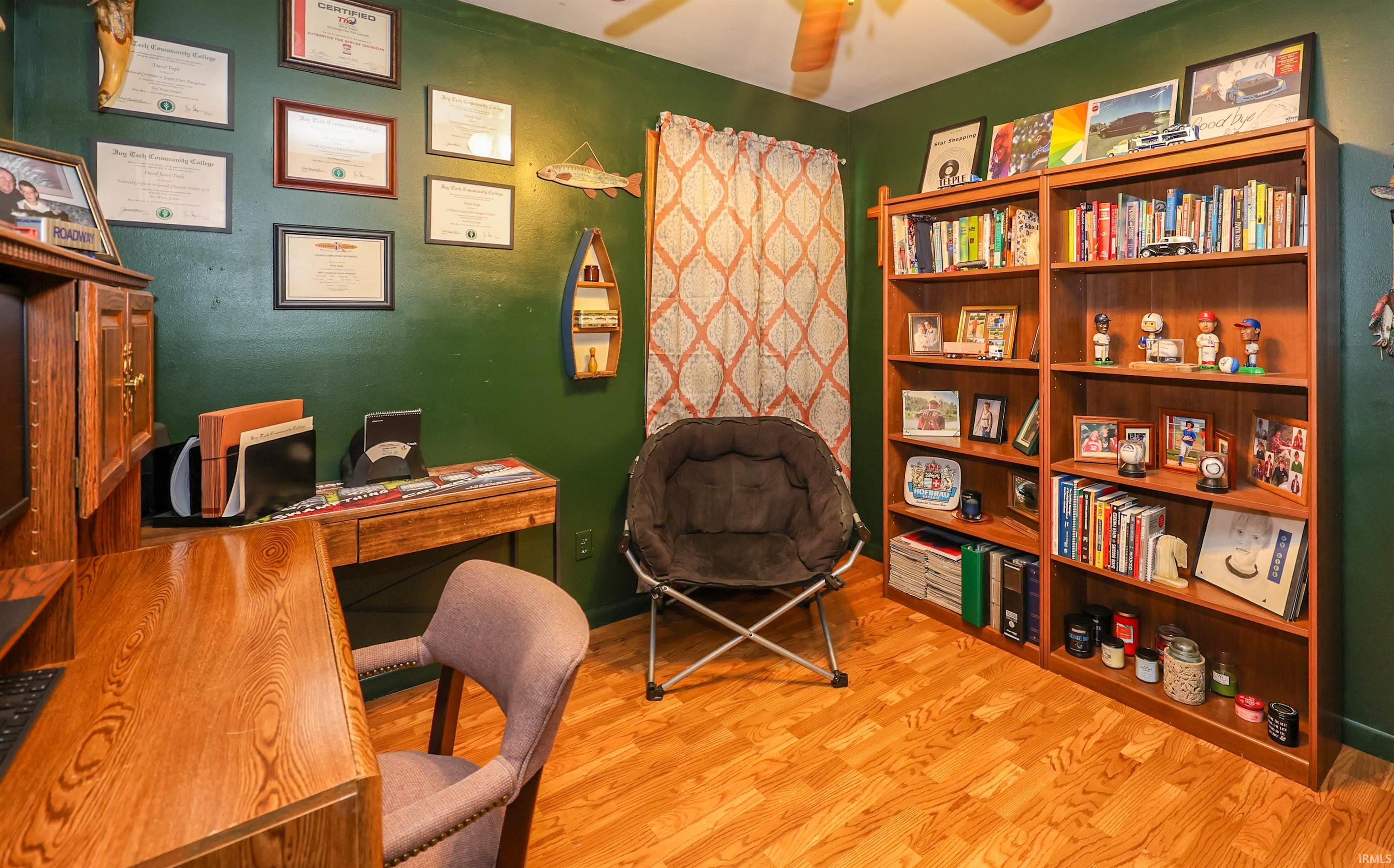 Hardwood-style flooring extends throughout this room, featuring rich green walls