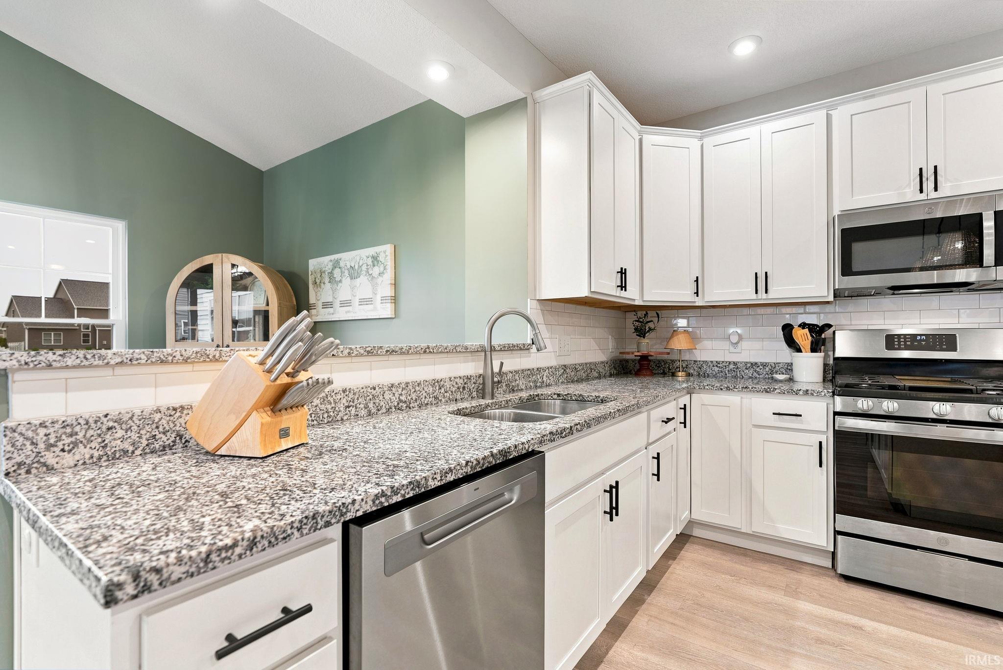 Modern kitchen featuring white shaker-style cabinetry with matte black hardware