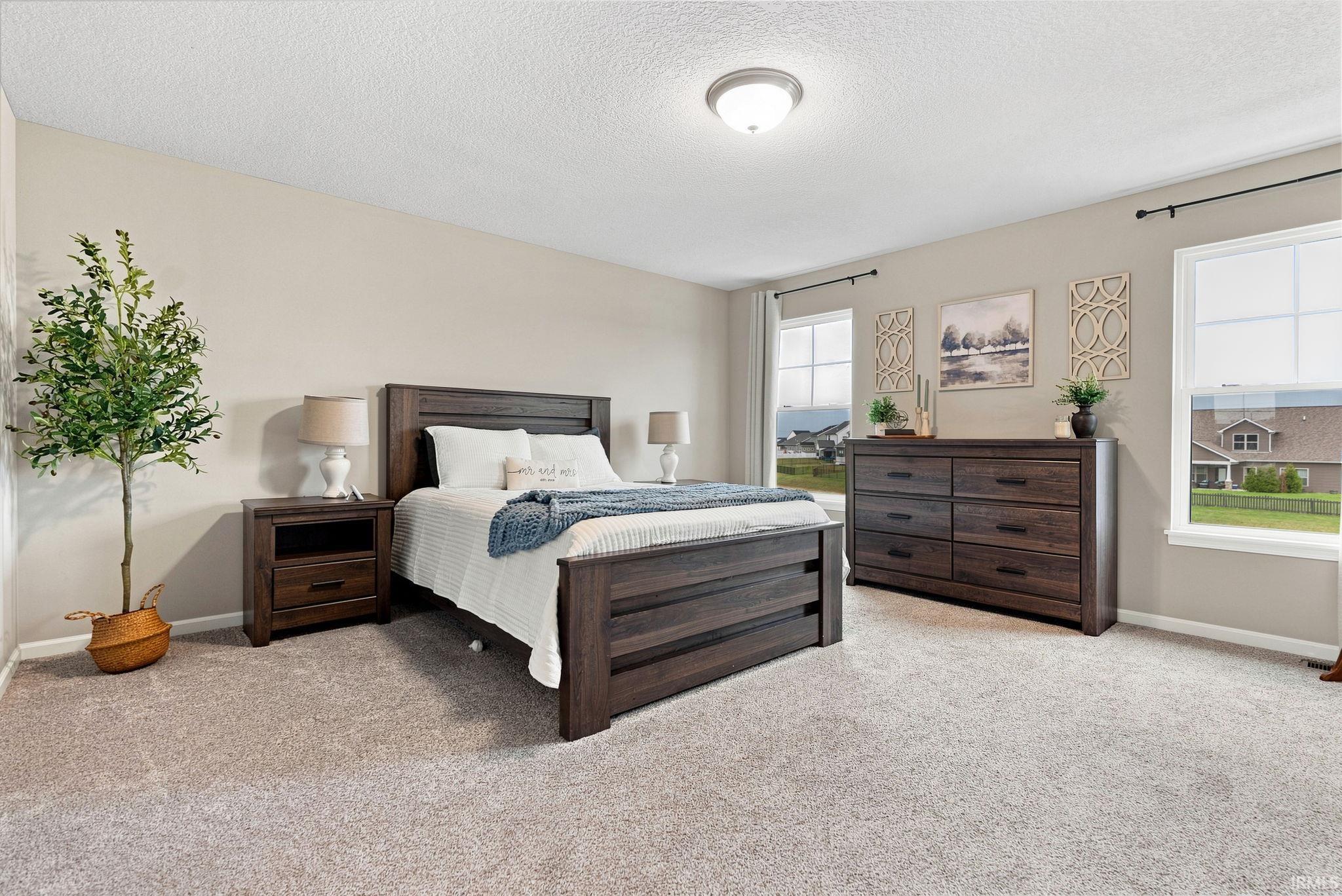 Spacious room featuring neutral wall tones and light-colored carpeting