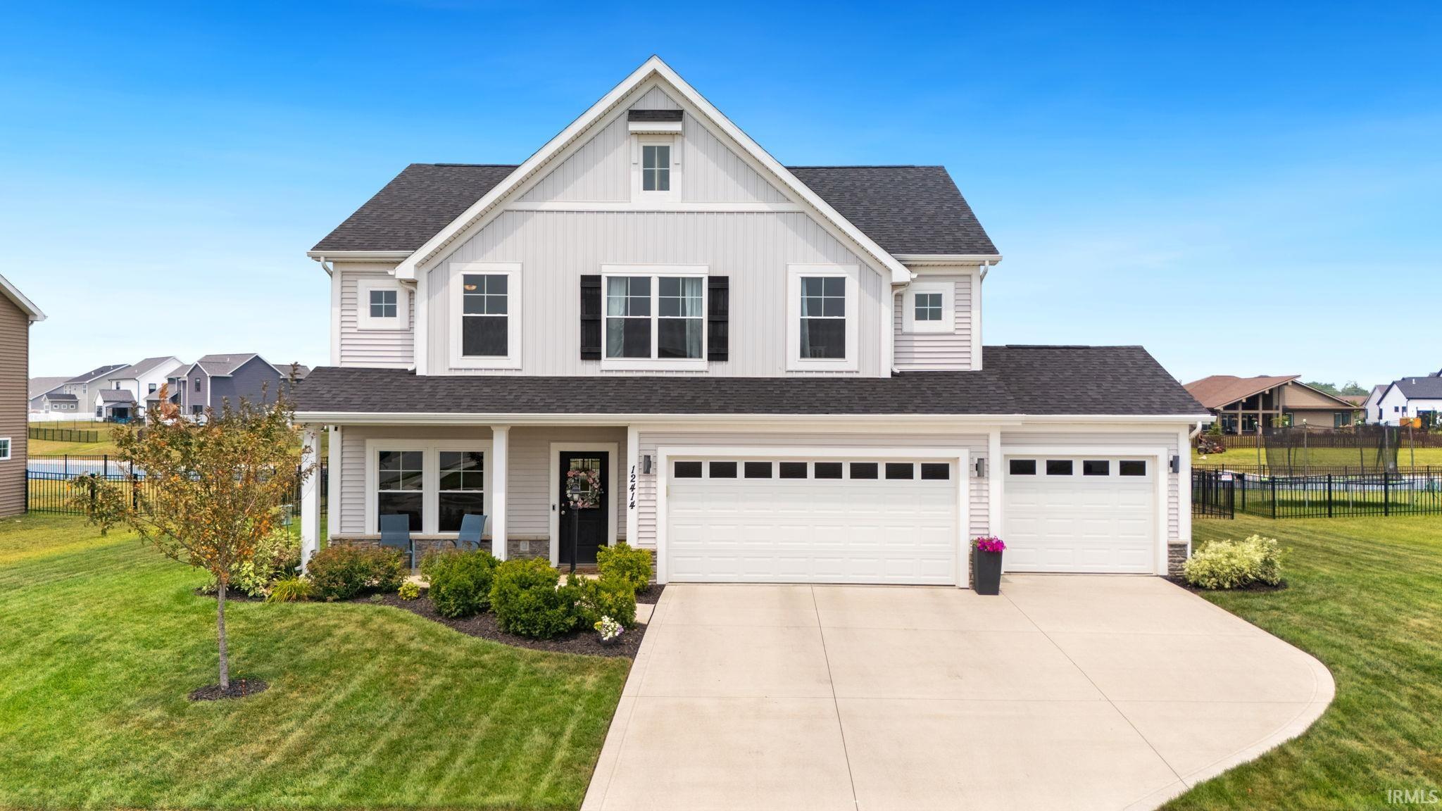 Two-story residence featuring light gray siding with white trim accents and a dark roof