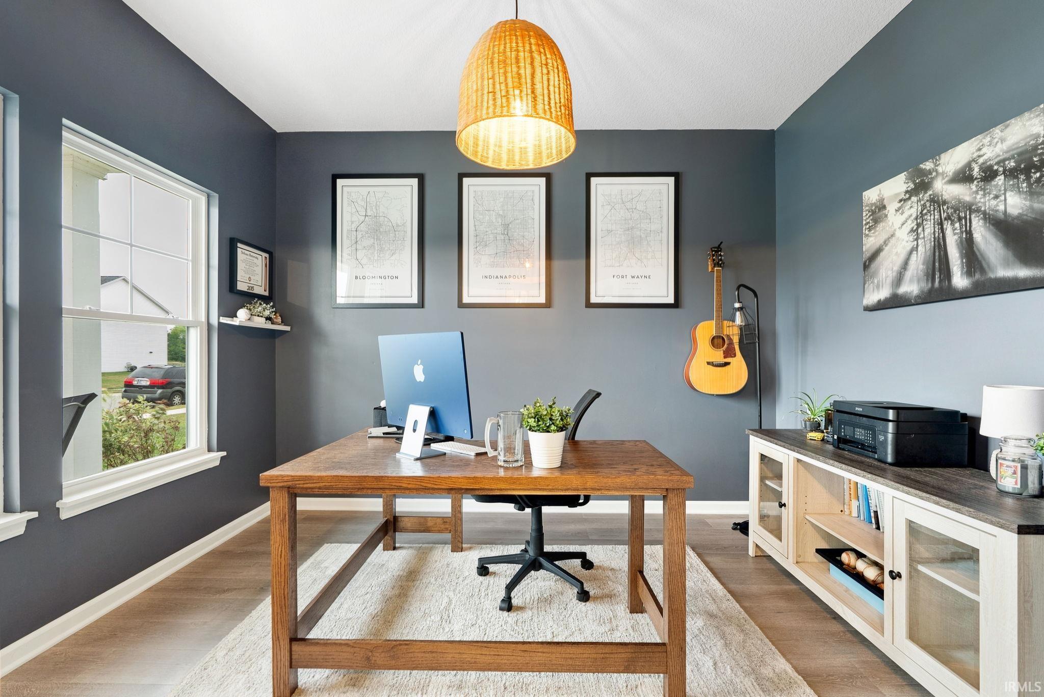 Spacious room featuring wood-finish flooring, a large window, and a built-in media console with glass-fronted cabinetry