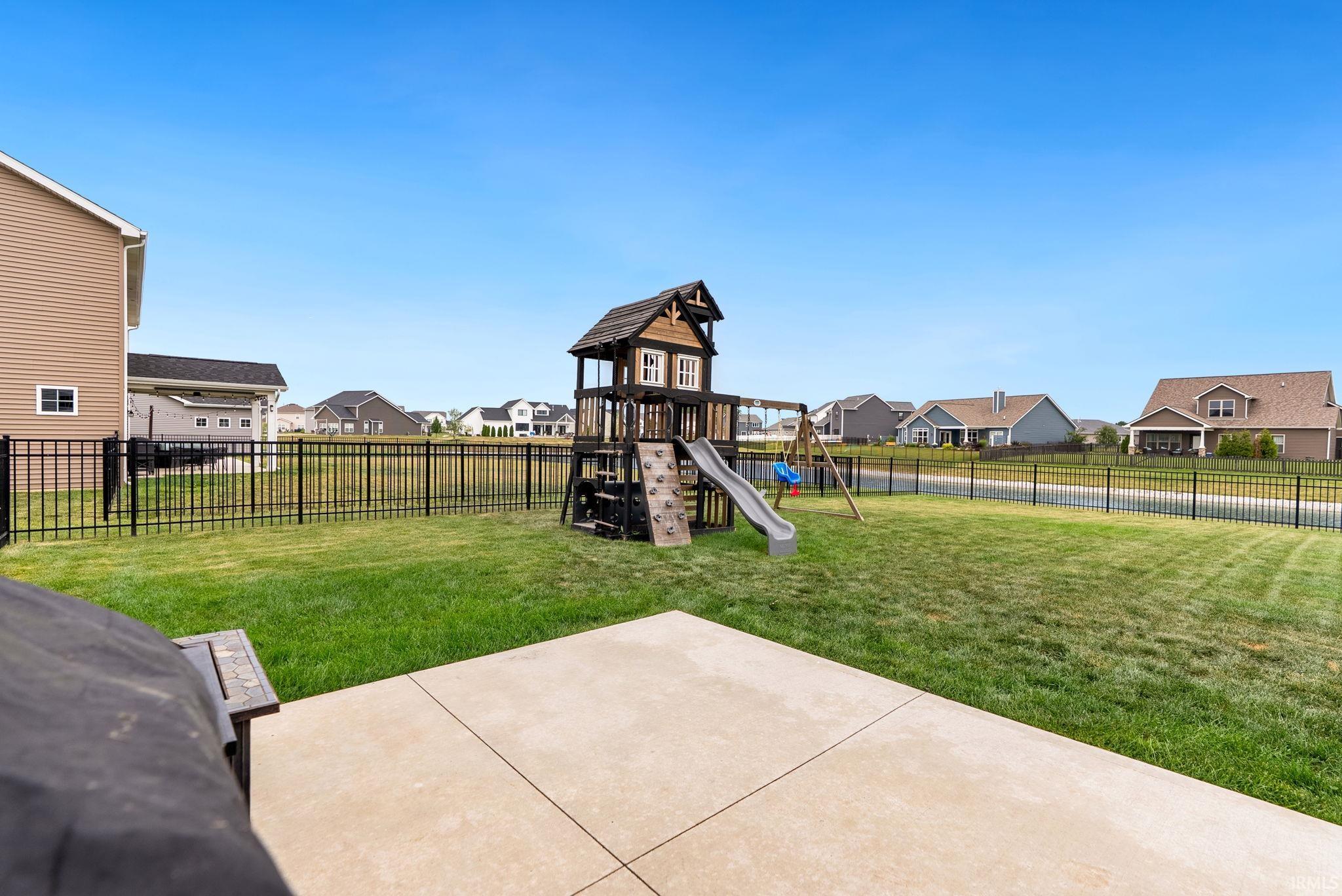Expansive green lawn featuring a black metal fence